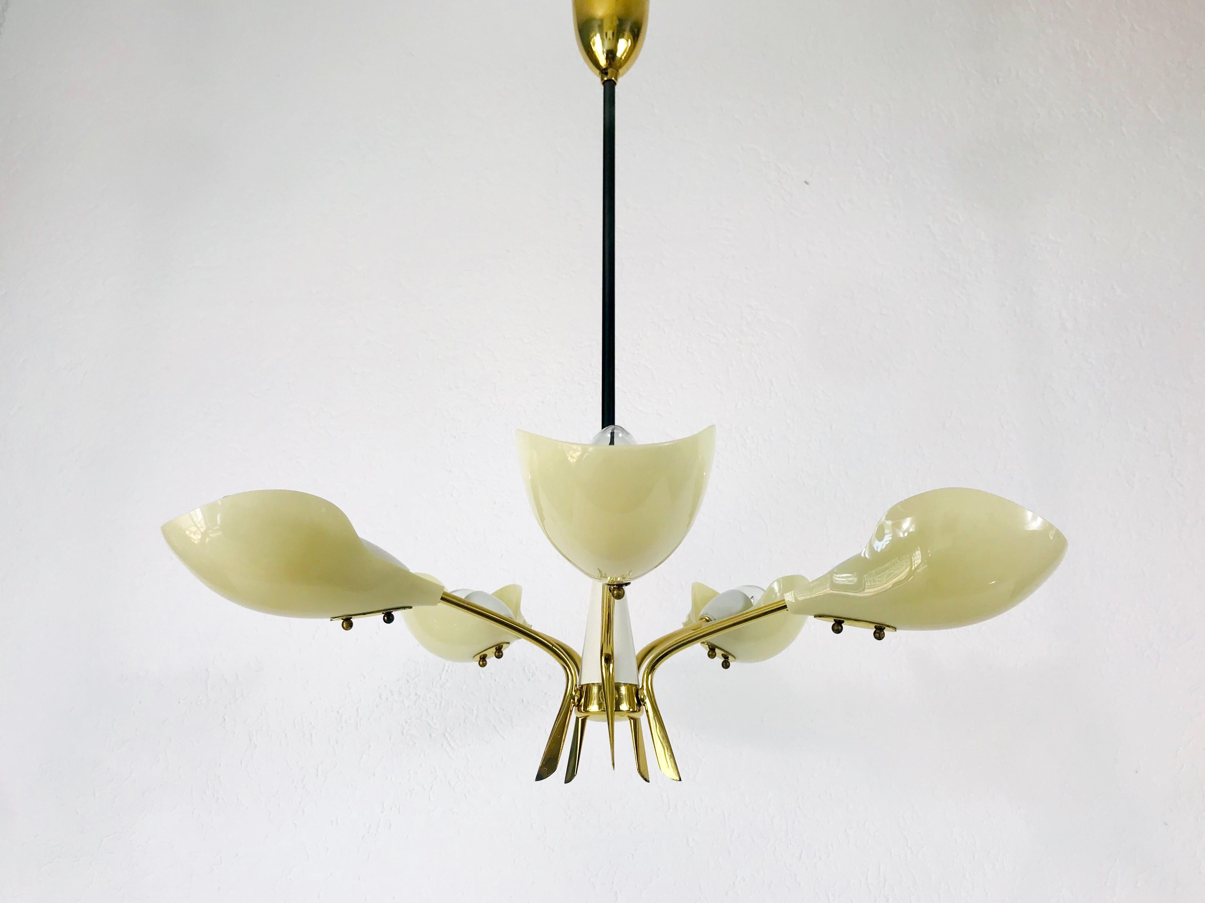 A Sputnik chandelier made in Italy in the 1950s. It is fascinating with its five brass arms, each of it with an E14 light bulb. The arms have a beige color. The shape of the light is similiar to a spider. 

Very good vintage condition.

The