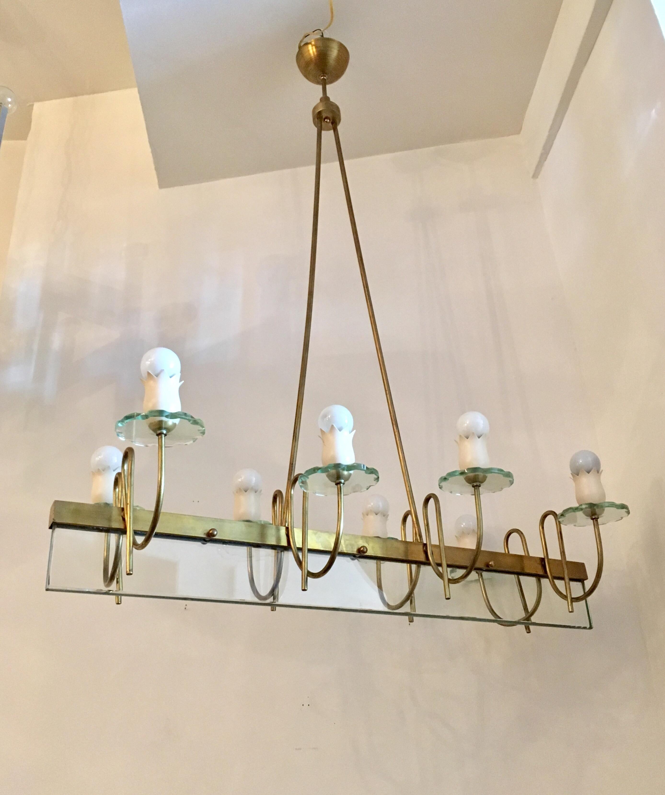 A wonderful all original 1950s Italian chandelier composed of a satin brass and white enamel fixture and fitting with one large cut crystal and eight small hand-cut crystal bobeches. Rewired. In the style of Fontana Arte. The height can be dropped