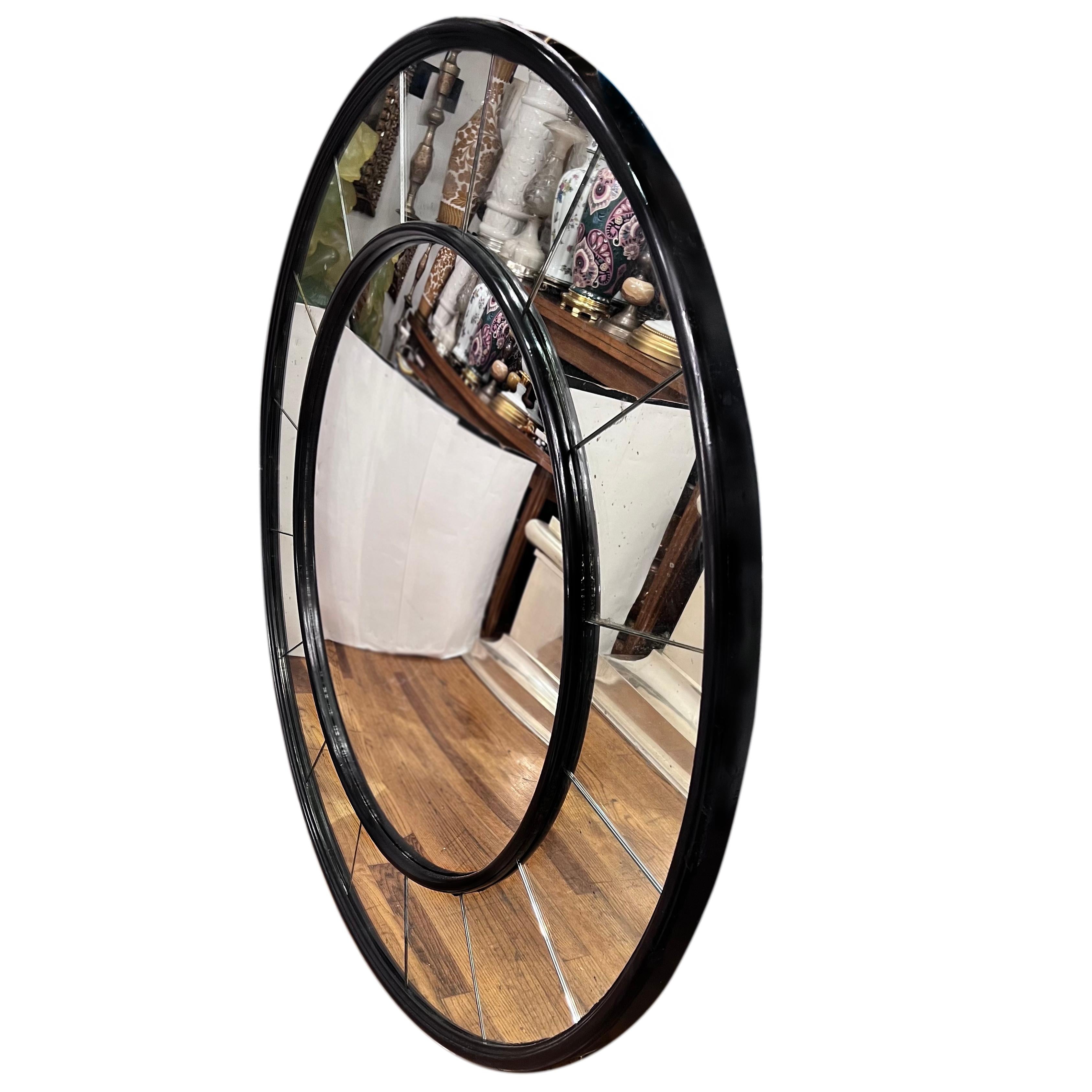 A circa 1960's Italian ebonized wood mirror with mirror panels frame.

Measurements:
Diameter: 46