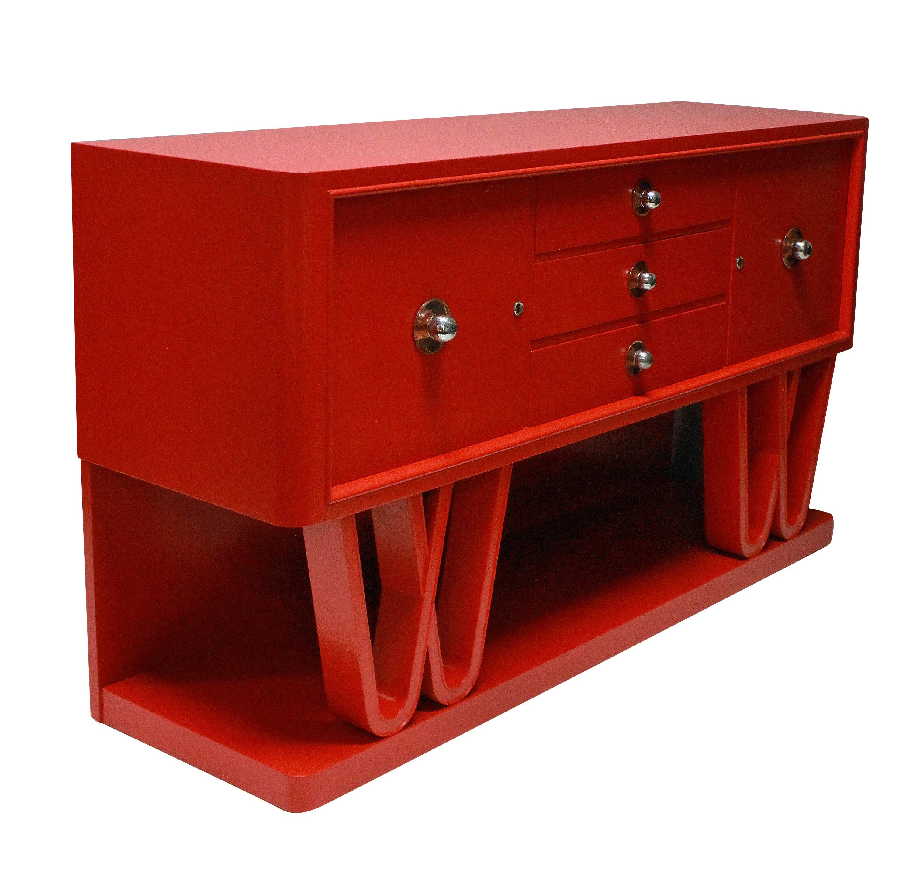 A stunning Italian midcentury credenza in scarlet lacquer, two cupboards and three drawers sit upon an attractive scrolled base. The handles of copper and chrome and the cupboards are lockable.
