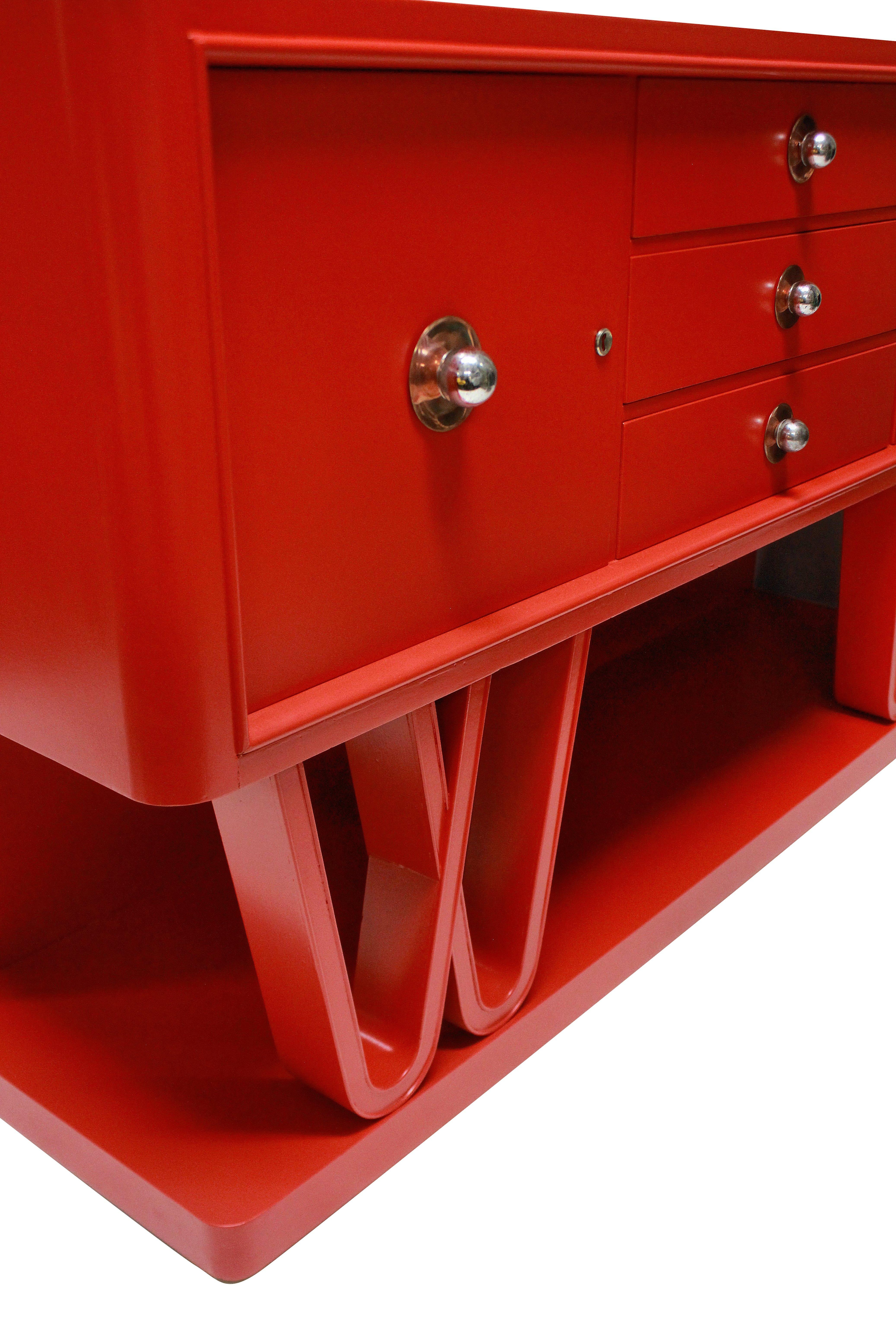 A stunning Italian midcentury credenza in scarlet lacquer, two cupboards and three drawers sit upon an attractive scrolled base. The handles of copper and chrome and the cupboards are lockable.