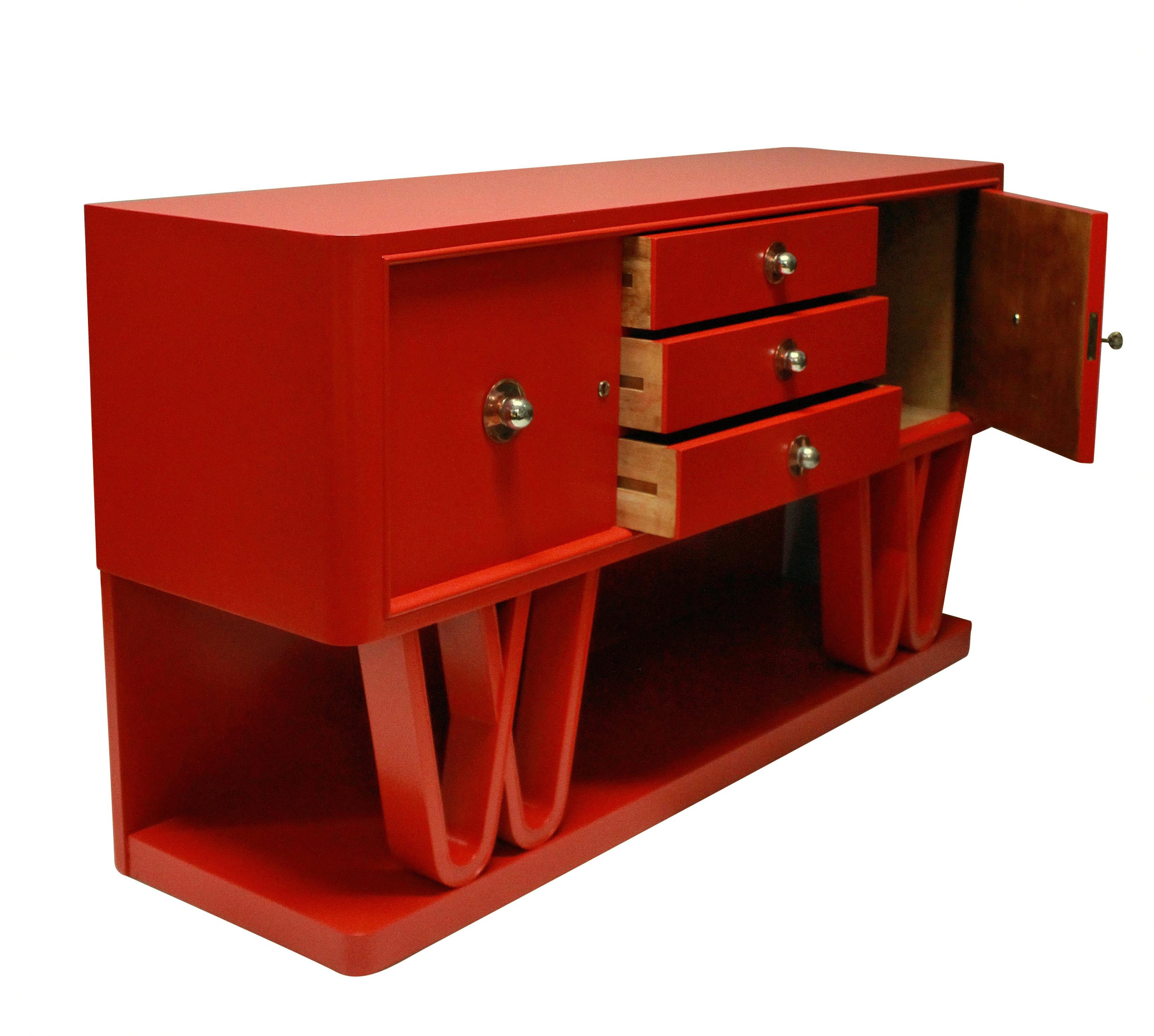 A stunning Italian midcentury credenza in scarlet lacquer, two cupboards and three drawers sit upon an attractive scrolled base. The handles of copper and chrome and the cupboards are lockable.