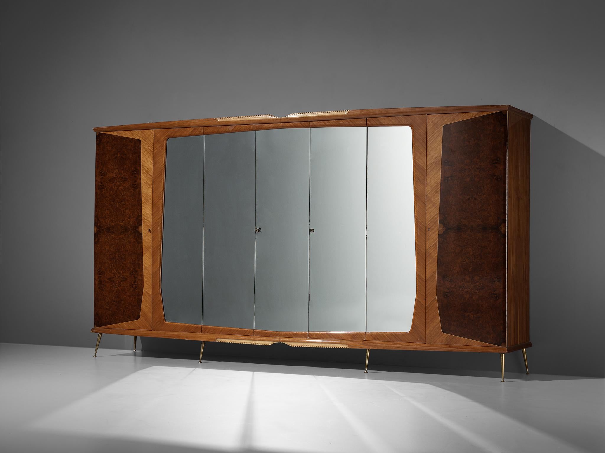 Wardrobe, walnut burl and veneer, glass, brass, Italy, 1950s

A beautiful and luxurious Italian wardrobe or very large cabinet. With its seven doors this wardrobe has an impressive size. Five doors hold a mirrored surface, the two outer doors show