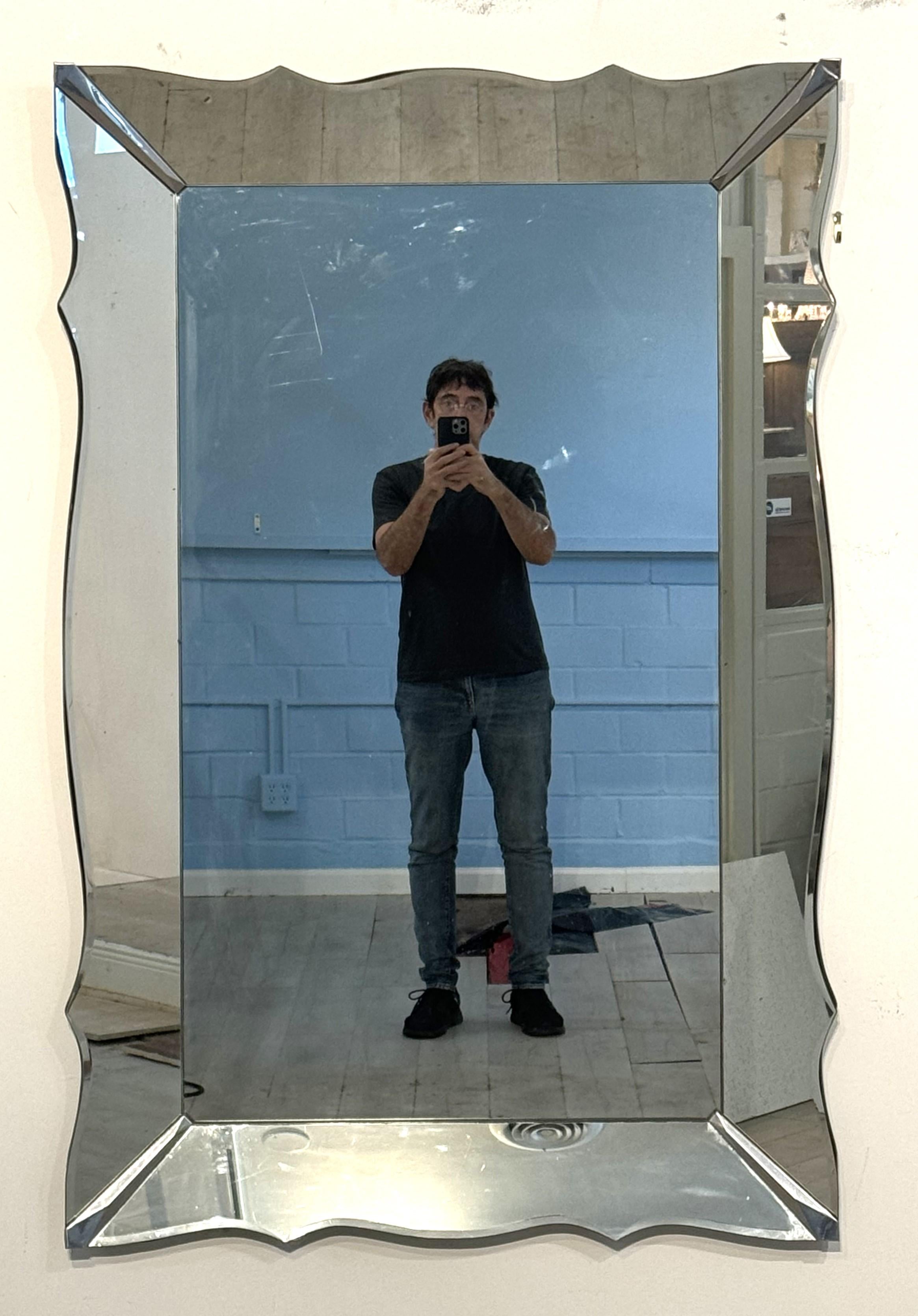 Ein feiner großer italienischer moderner Wand- oder Ankleidespiegel in voller Länge - ein schräger, serpentinenförmiger Spiegelrand mit Chromakzenten an den Ecken, der einen rechteckigen Spiegel in der Mitte umgibt - mit einem sauberen Design aus