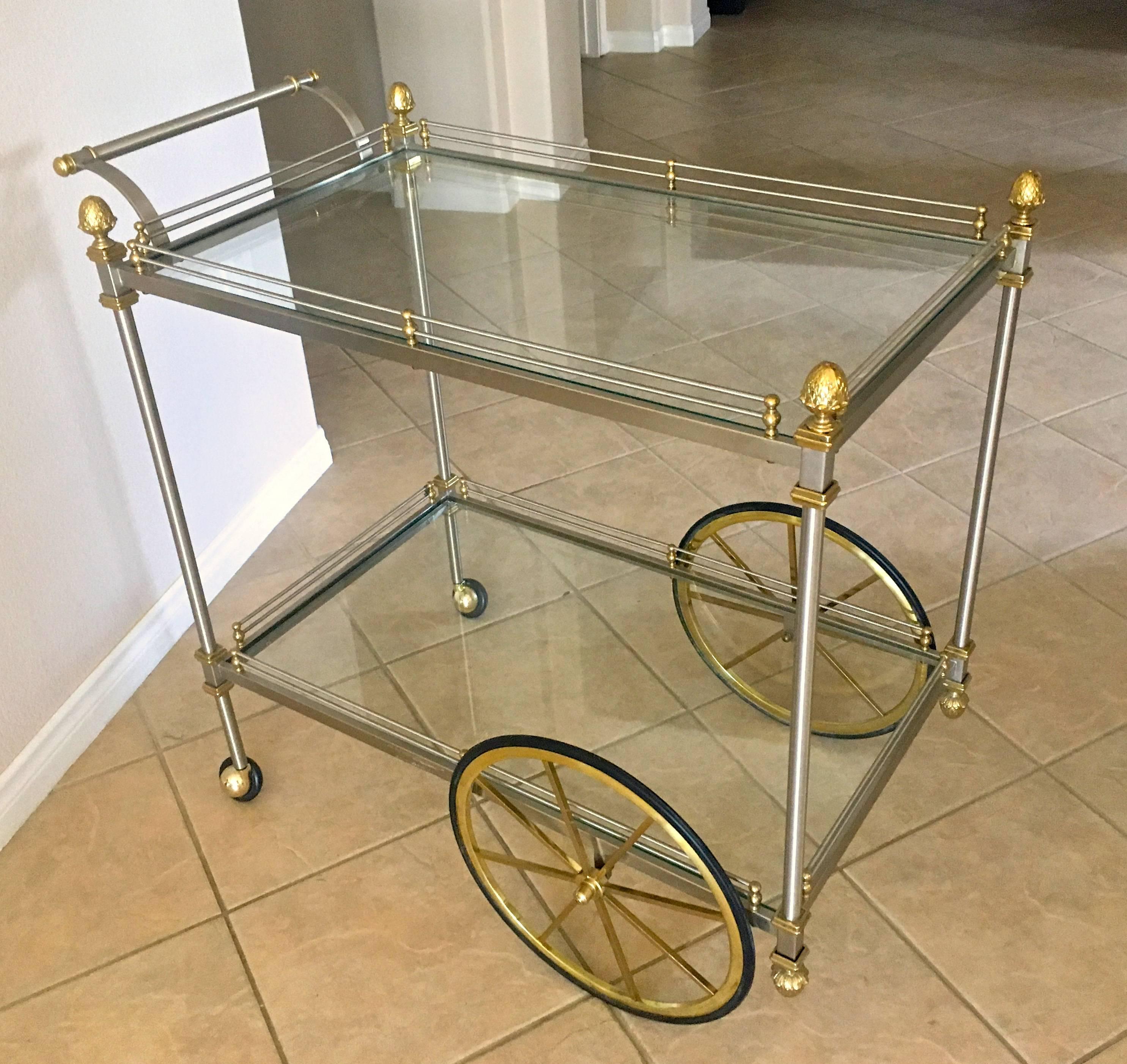 Larger scale brass and brushed steel Italian bar or tea cart, with two-tier glass shelves, gallery rail and acorn finial details.


 