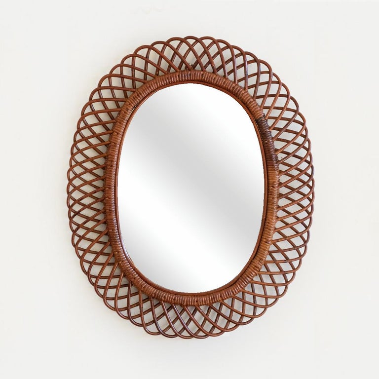 Beautiful large oval rattan mirror in the style of Franco Albini from Italy, 1960's. Great size, perfect for bathroom or entryway. Nice vintage condition with dark finish and original mirror.