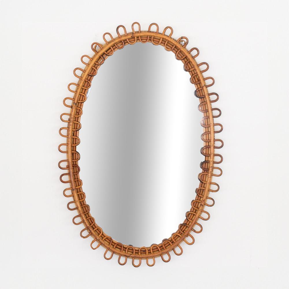 Grand miroir italien en rotin de forme ovale avec des boucles de rotin entourant le miroir. Bel état vintage avec finition et miroir d'origine. Parfait pour une salle d'eau.