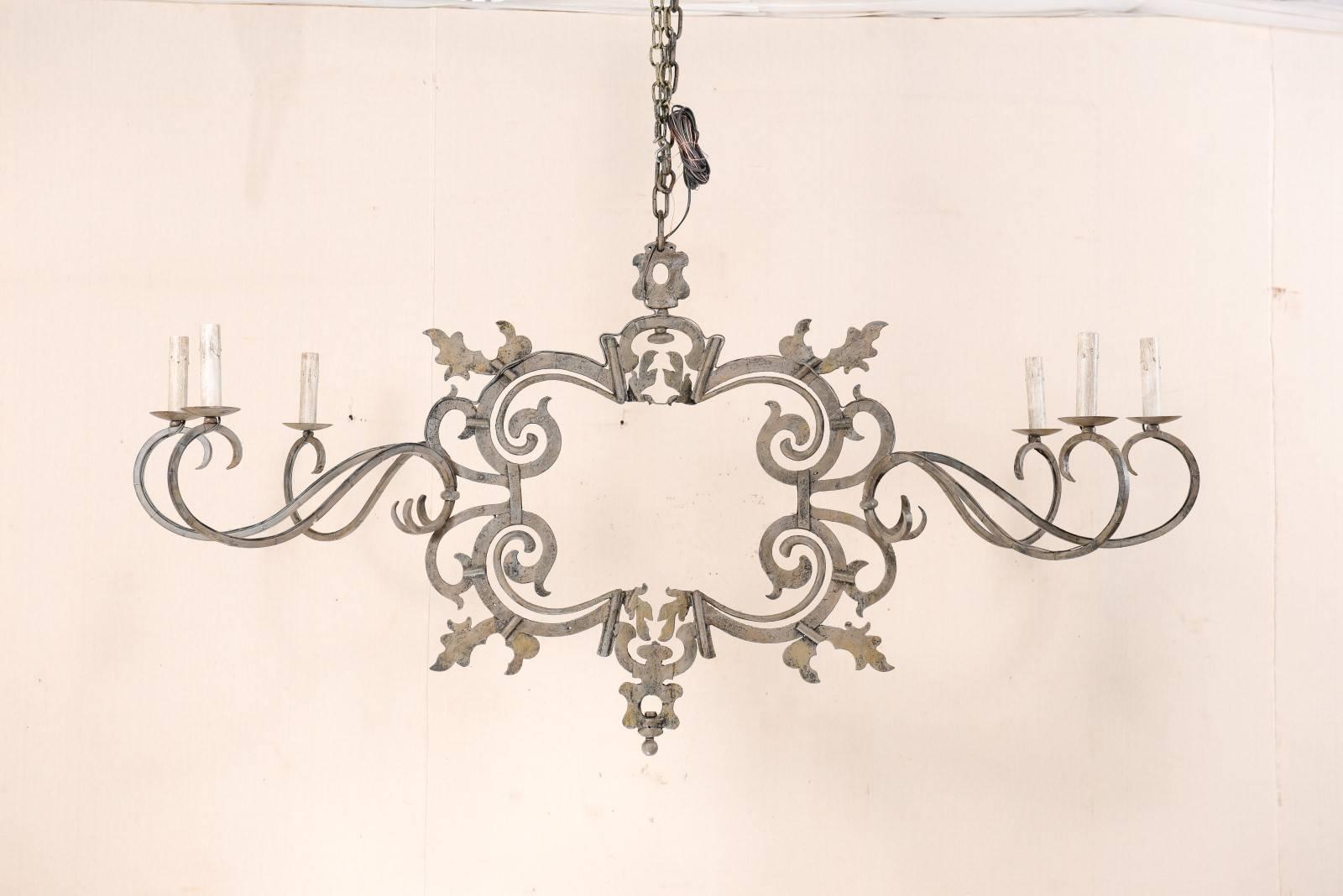 This very special and large-sized chandelier has been custom fashioned from 18th century ironwork. This Italian chandelier with it's impressive spread of over 6 feet wide, features an 18th century decorative iron work centre, likely once the ornate