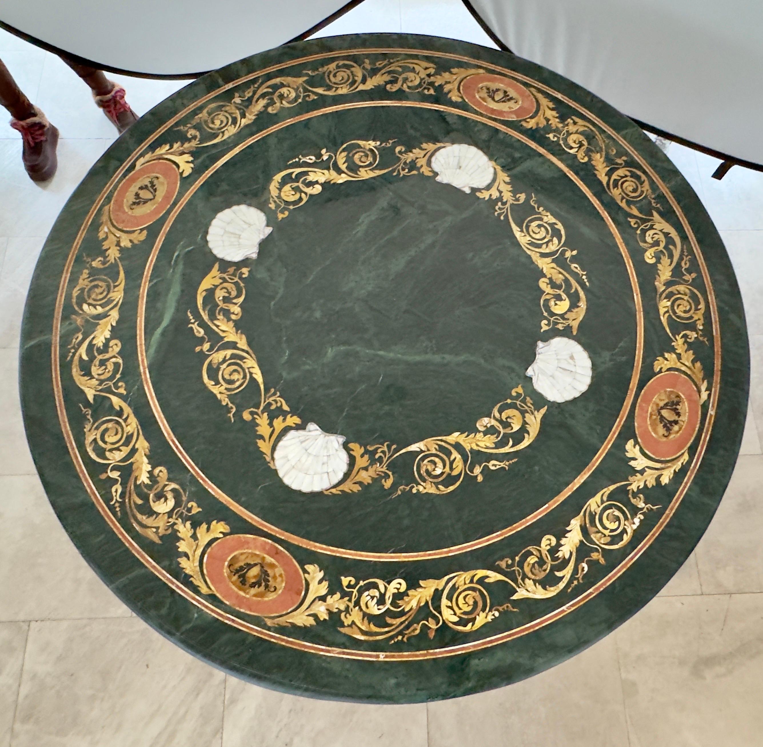 Ein prächtiger Pietra Dura-Sockel-Mitteltisch, der in üppigem grünen Marmor erstrahlt. Dieses opulente Stück besticht durch ein kompliziertes florales Mosaik aus Perlmuttmuscheln, das zart mit den anmutigen Motiven von Schriftrollen und