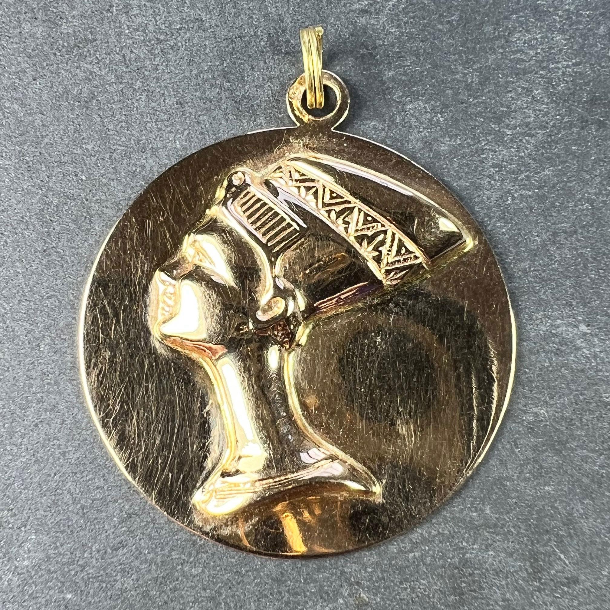 A large Italian 18 karat (18K) yellow gold charm pendant designed as a three dimensional bust of the head of Queen Nefertiti in profile within a flat gold circle. Stamped with the Italian maker's mark 226VI indicating manufacture in Vincenza after