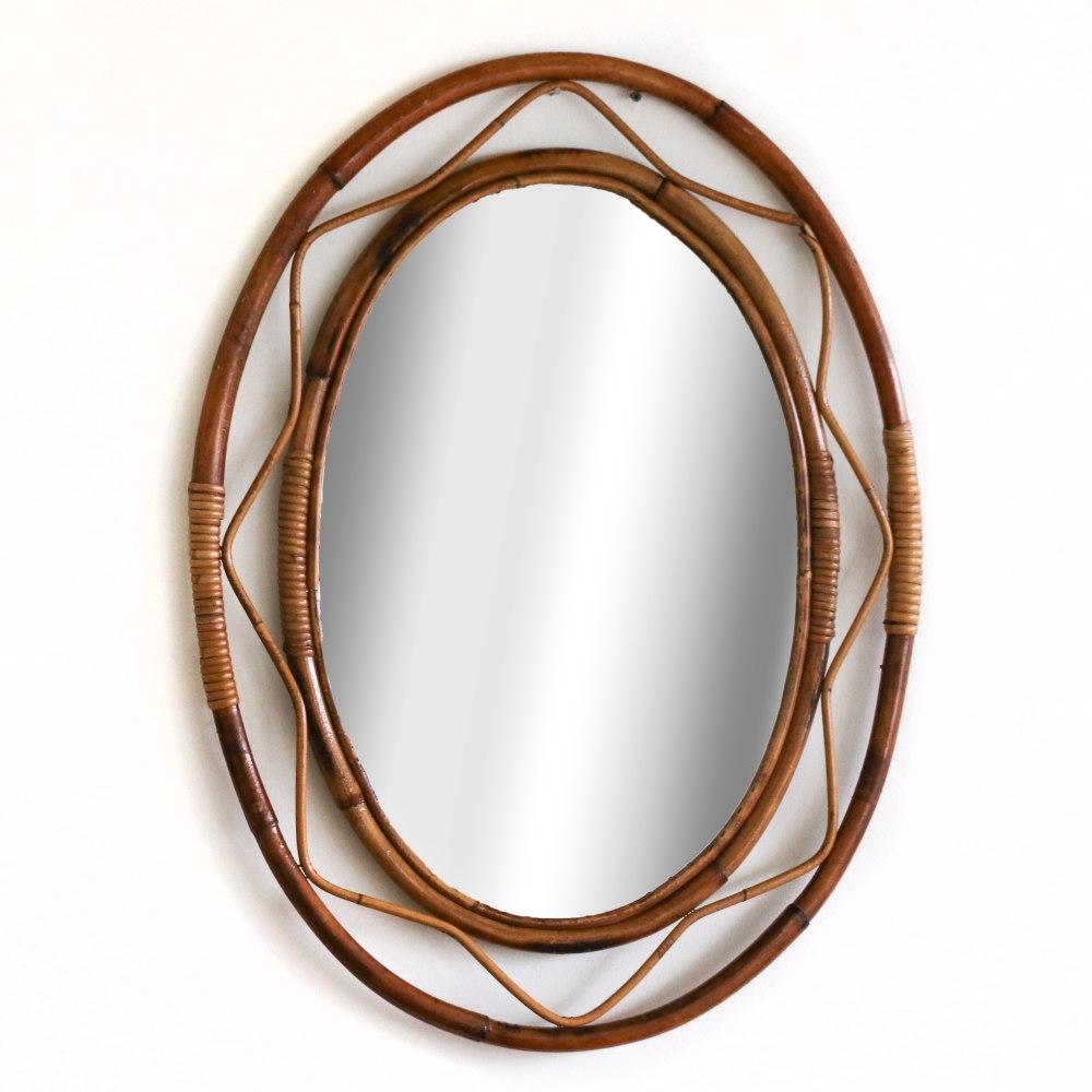 Magnifique miroir en rotin de forme ovale, Italie, années 1960. Design/One unique avec du rotin ondulé en zig-zag entourant le miroir. Belle condition vintage avec le cadre en rotin et le miroir d'origine.