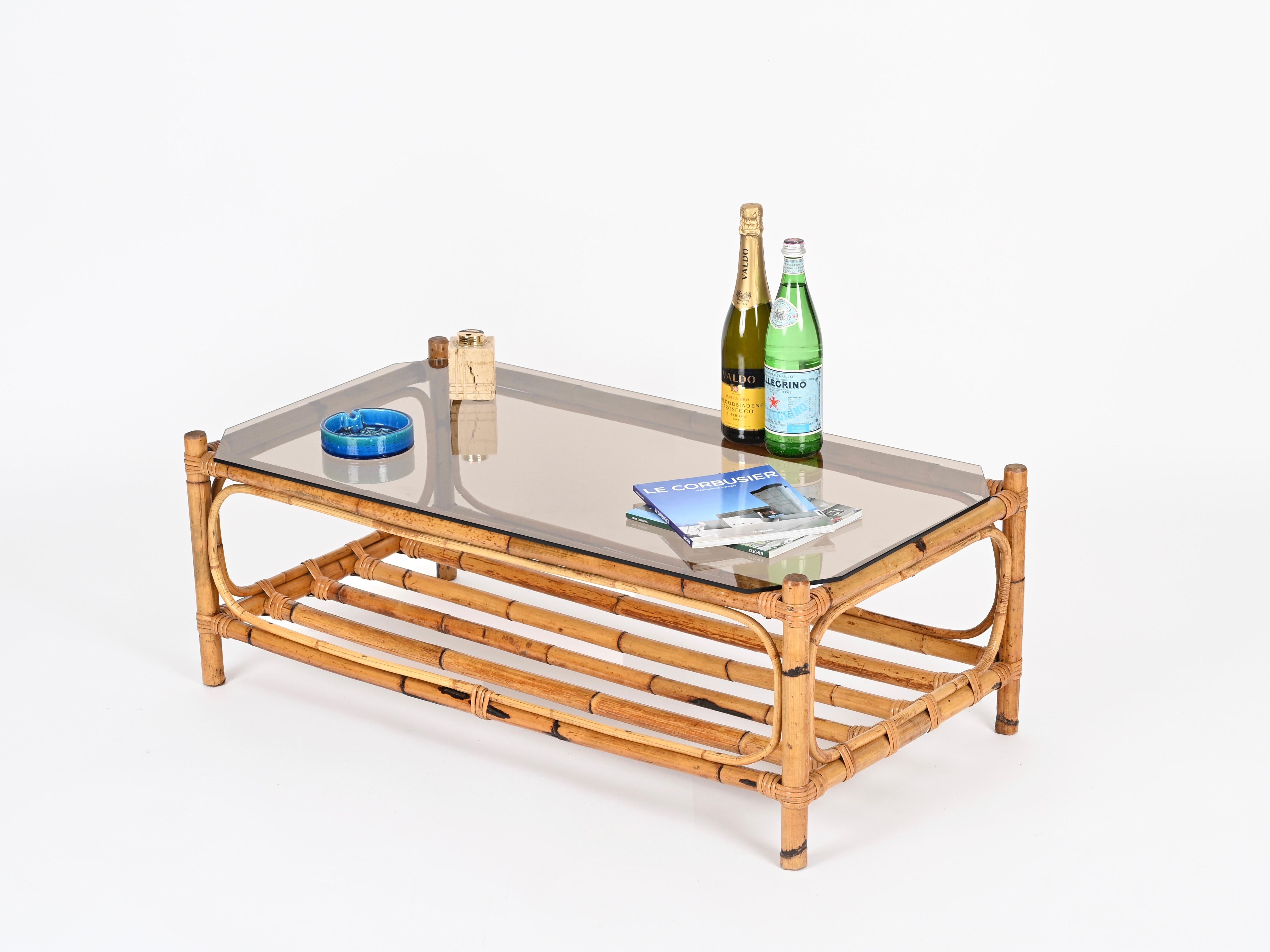 Stunning French Riviera style rectangular organic coffee table fully made in bamboo and woven rattan wicker completed by a bronzed glass top. This stylish and unique piece was hand-made in Italy during the 1970s.

This stylish organic table in