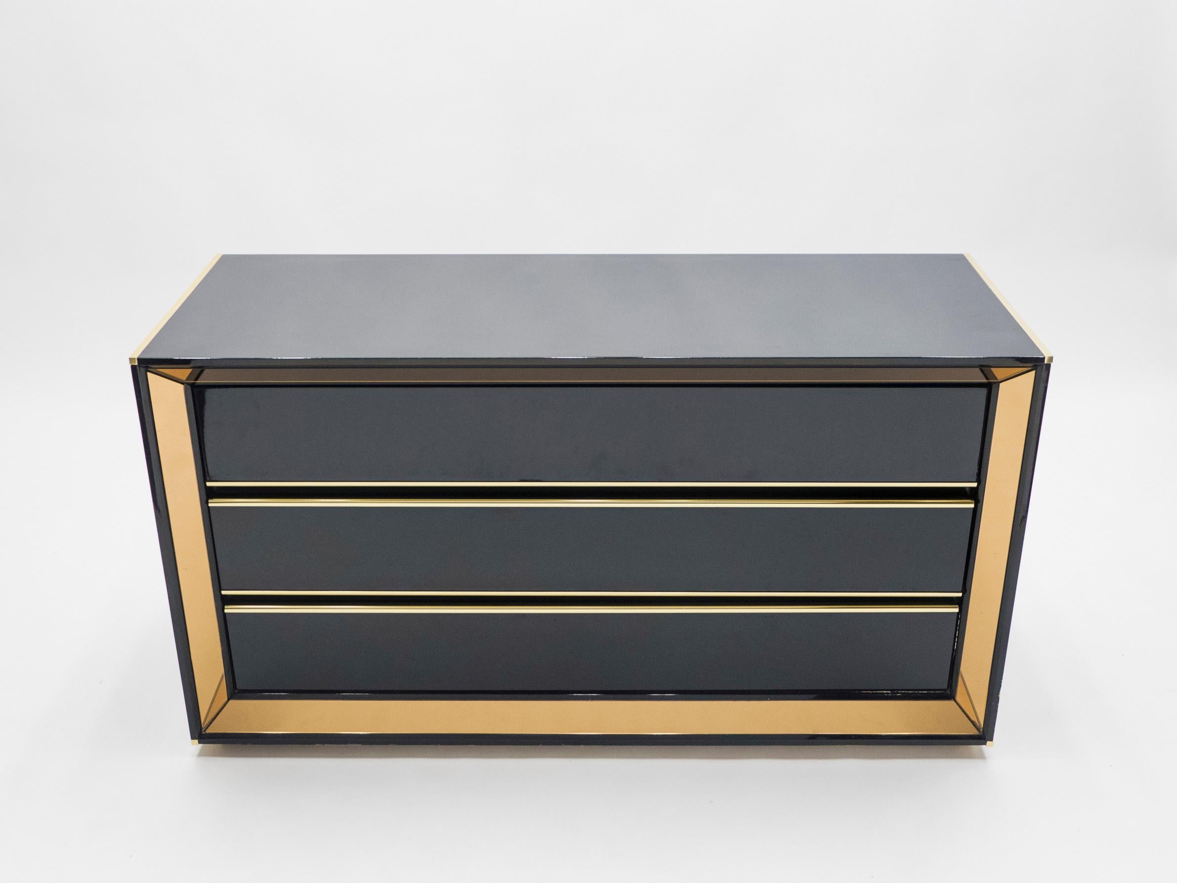 This Italian Hollywood Regency black lacquered chest of drawers would be stunning in any room. The shiny black lacquer coating is the appropriate match to the bronze-tinted mirror frame, both reflecting light in a subdued way and creating a chic