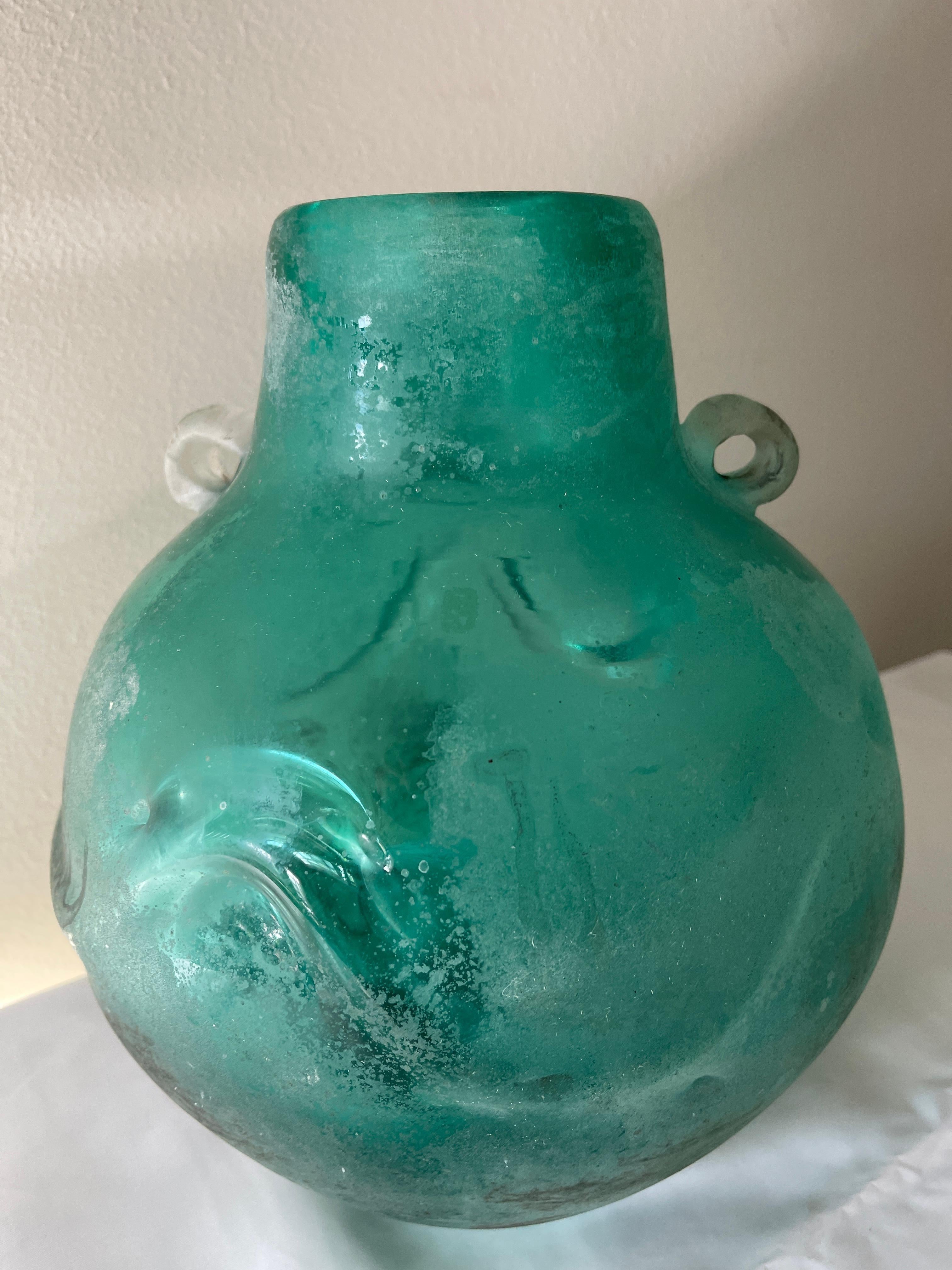 Large Italian Scavo Corroso glass urn vase with 2 handles and gorgeous raised wave design surrounding the middle. Mesmerising to look at!
This piece evokes the beautiful aquamarine sea, and is an Avalon favourite. 
Nice heavy weight to the piece.