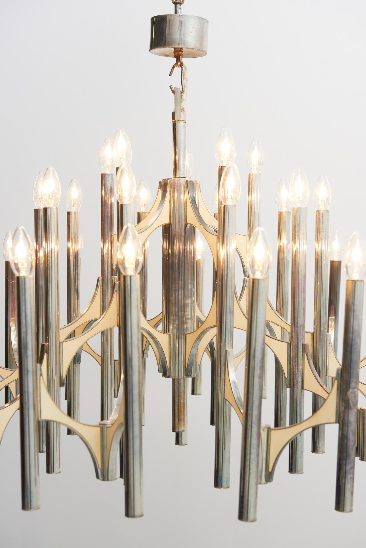 A large Italian chandelier from the 1970s designed by Gaetano Sciolari. Chrome plated brass with cream metal panels are holding the 35 light bulbs that are linked to each other and placed around a central rod.