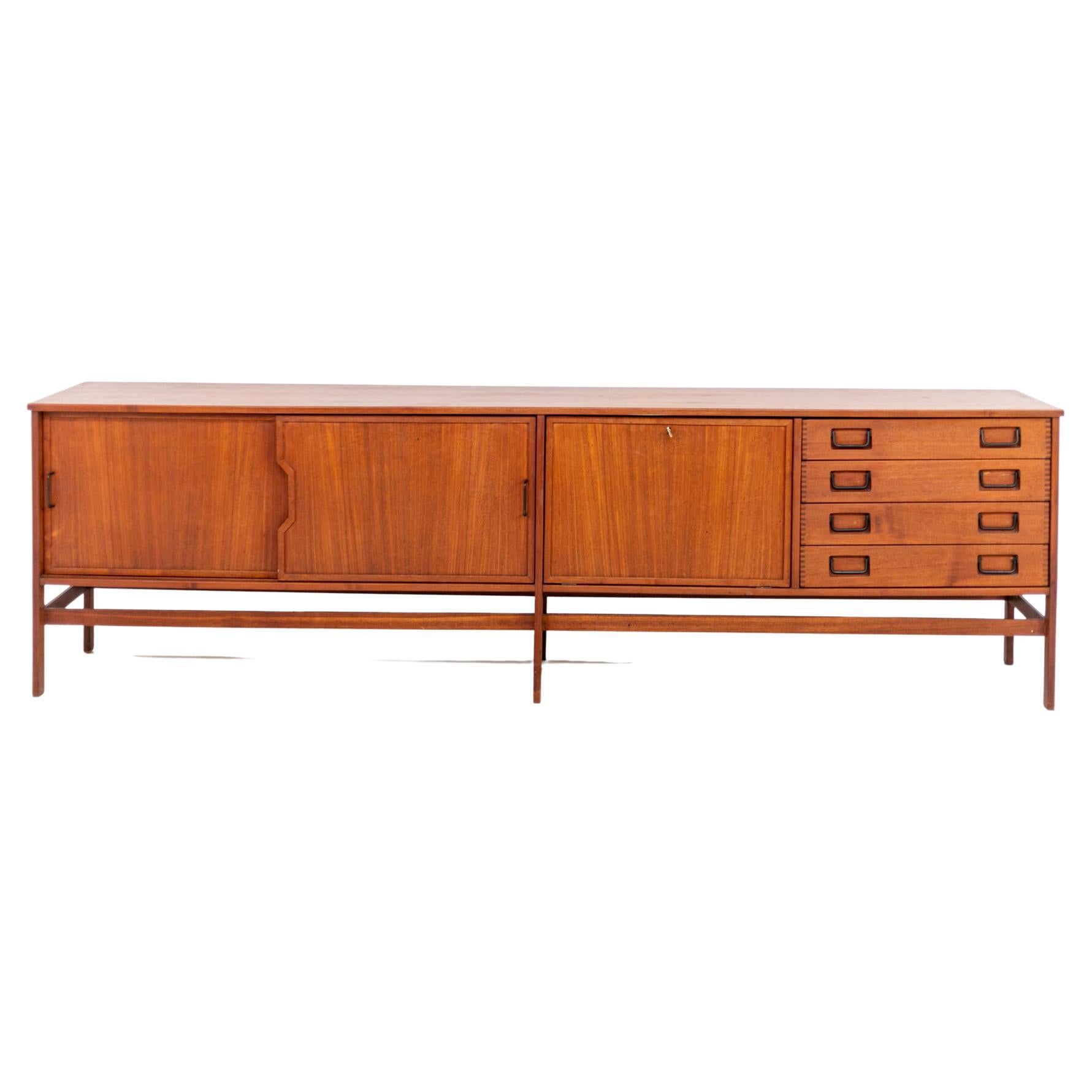 Large Italian sideboard by Cantieri Carugati in wood and metal from the 1960s. 
The large sideboard is egregiously crafted in various wood species. The cabinet is made with two sliding doors that can be opened by two metal handles. On the side