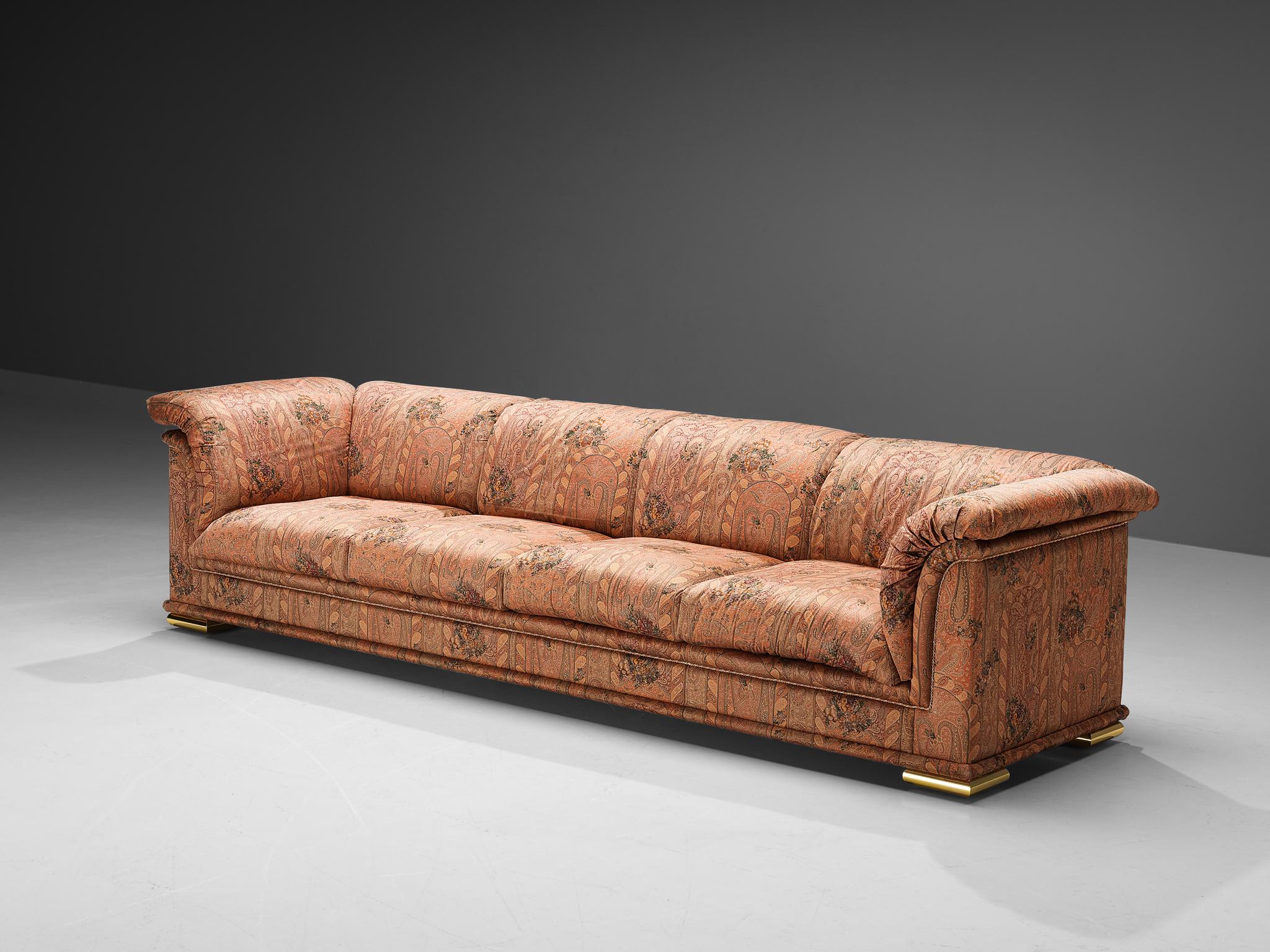 Sofa, fabric, metal, Italy, 1970s. 

Magnificent four seater sofa executed in a lively paisley print fabric upholstery. The satin weave of the fabric enlarges the alluring feeling this grand sofa radiates. The bulky stuffing of the seating and