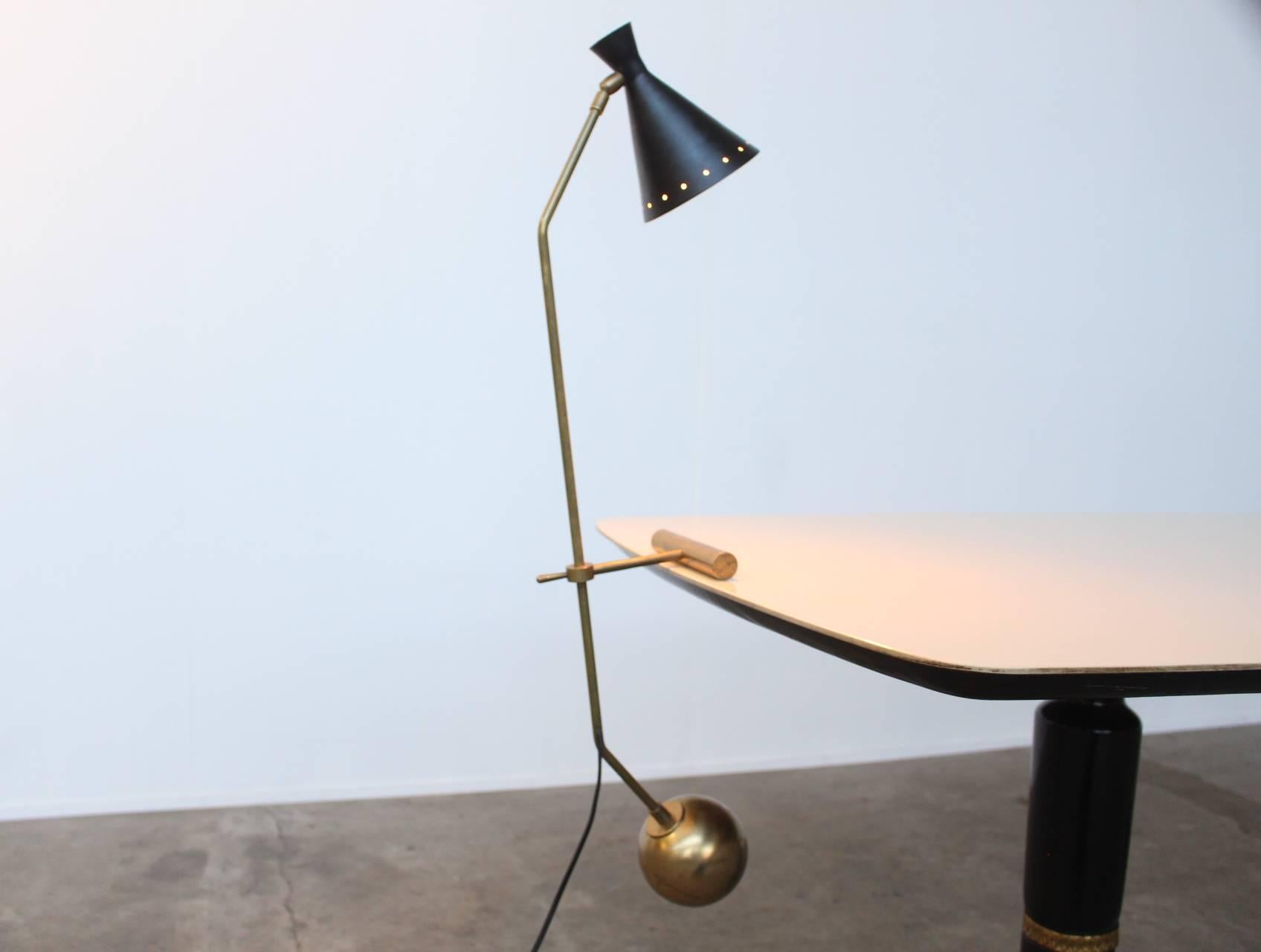 Beautiful elegant counter weight desk or table lamp identical to Stilnovo. The lamp balances and swings freely on the table edge by means of the weight of the solid brass counter balance ball. The lamp is height adjustable and the shade is in