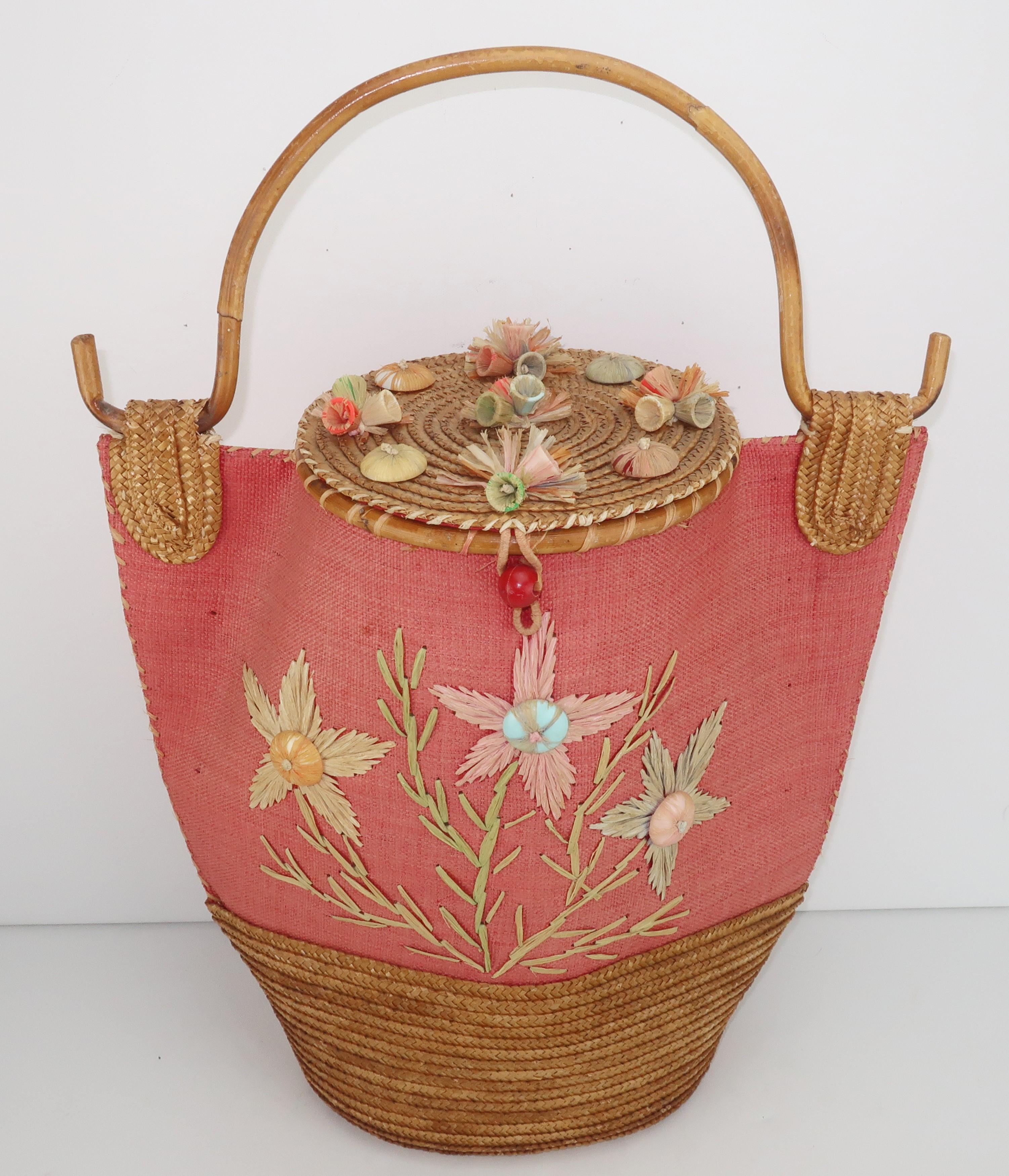 This look would be right at home on the Riviera ... an amazing 1950's Italian straw handbag with bamboo handle and raffia decoration.  The coral grasscloth body has a straw base and lid with raffia decorated plastic buttons and bells incorporating
