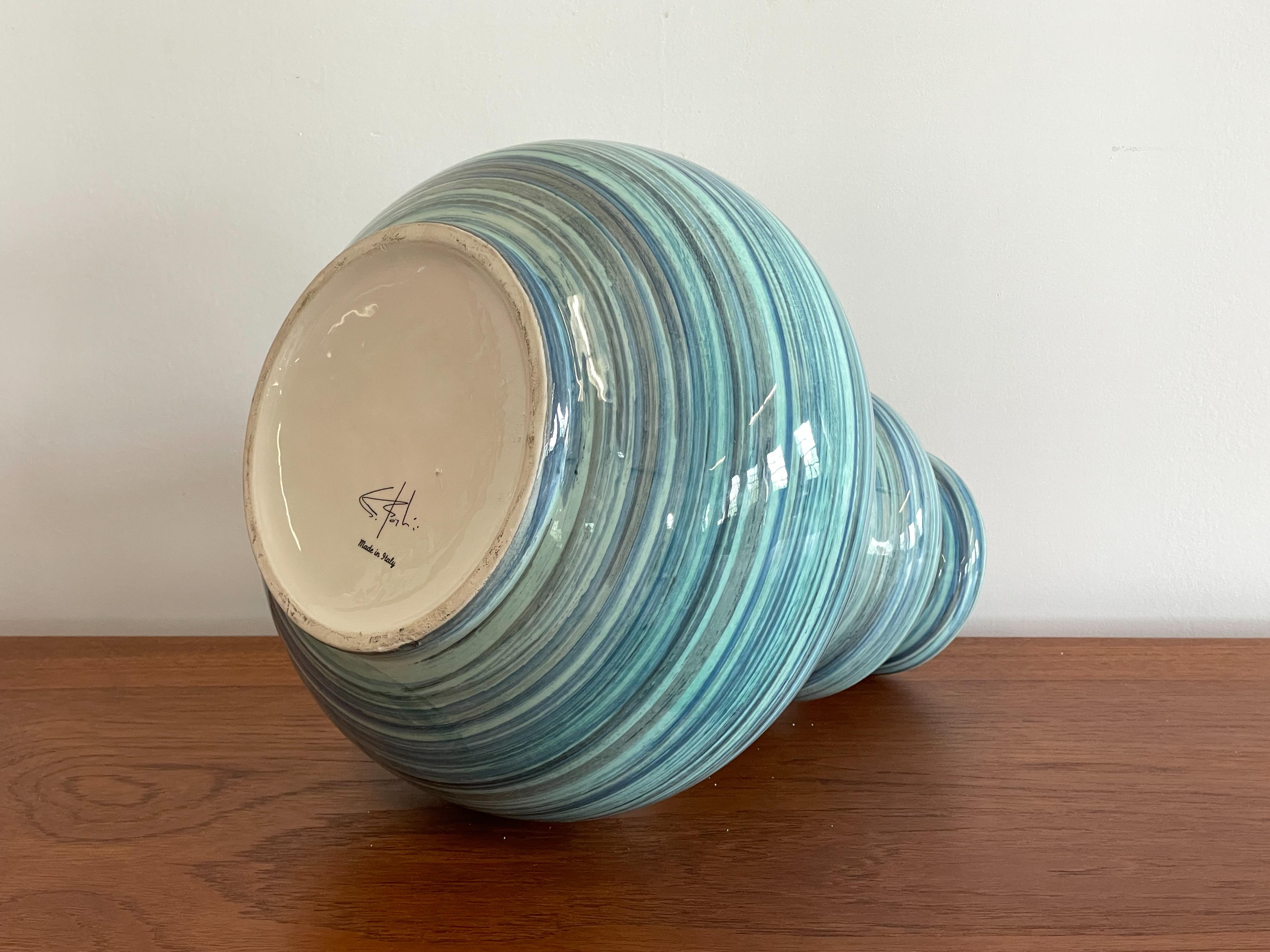 Large striped ceramic vase by unknown maker in the manner of Aldo Londi for Bitossi. This stunning piece features an undulating form with monochrome blue banding with a high gloss glaze. The interior features a rich contrasting orange glaze. It is