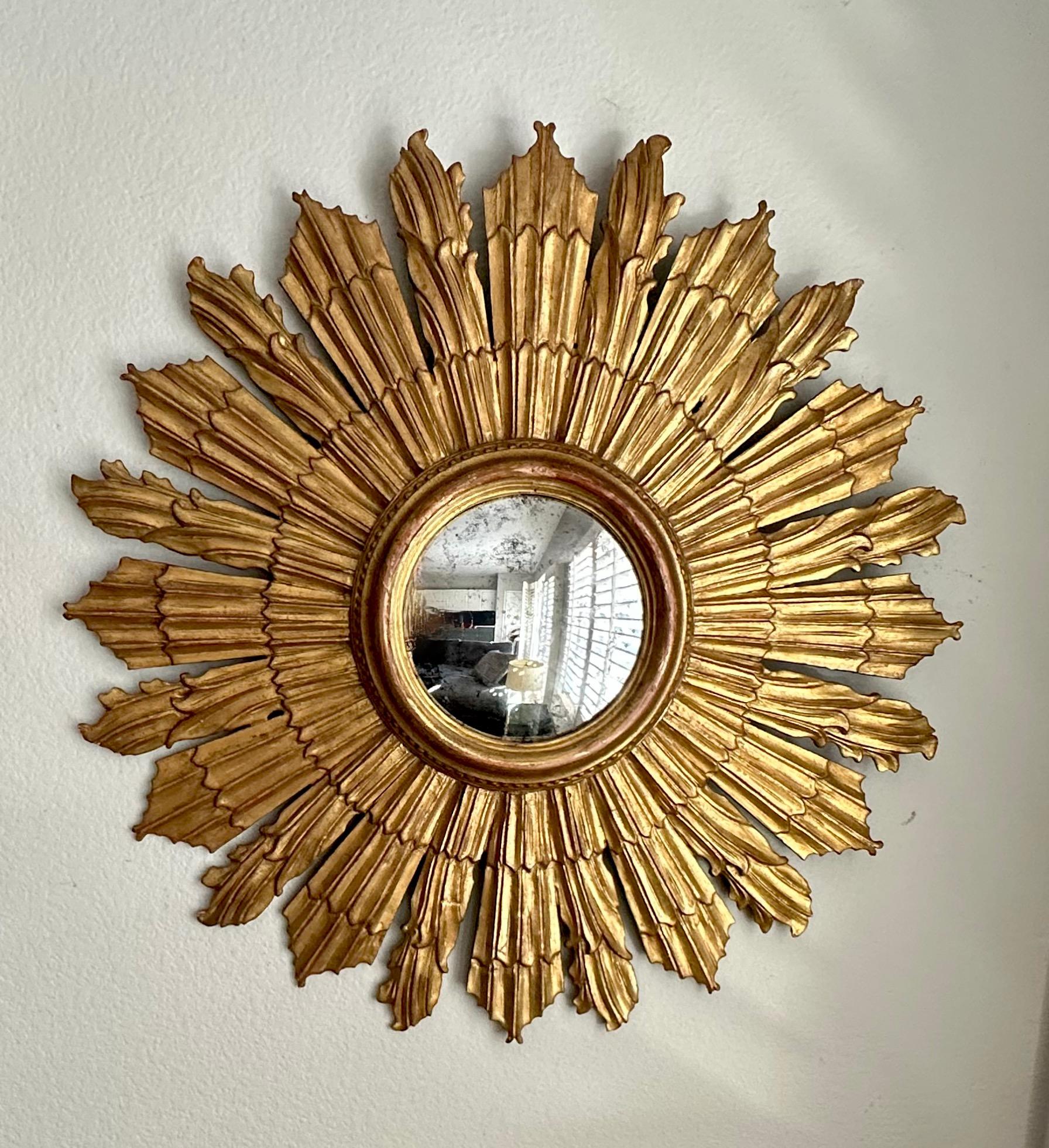 Beautifully crafted large Italian sunburst or starburst carved giltwood wall mirror with inset aged convex mirror. Diameter of mirror 7.5