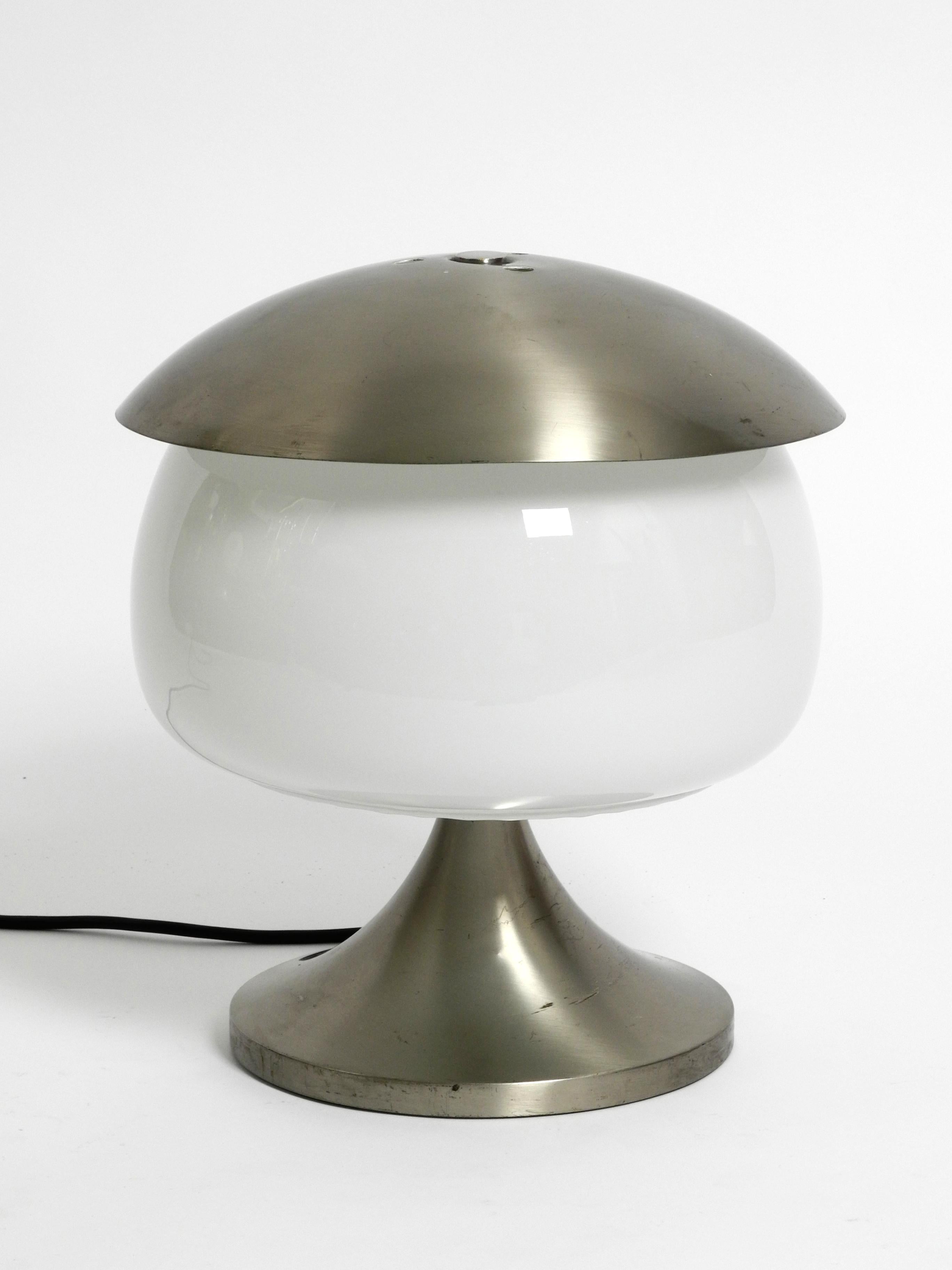 Rare large Italian table lamp made of solid aluminum and glass in space age design.
The base and the upper shade are made of thick, brushed aluminum. Large frosted glass shade.
Very good vintage condition with no damage to the frame, 
no dents