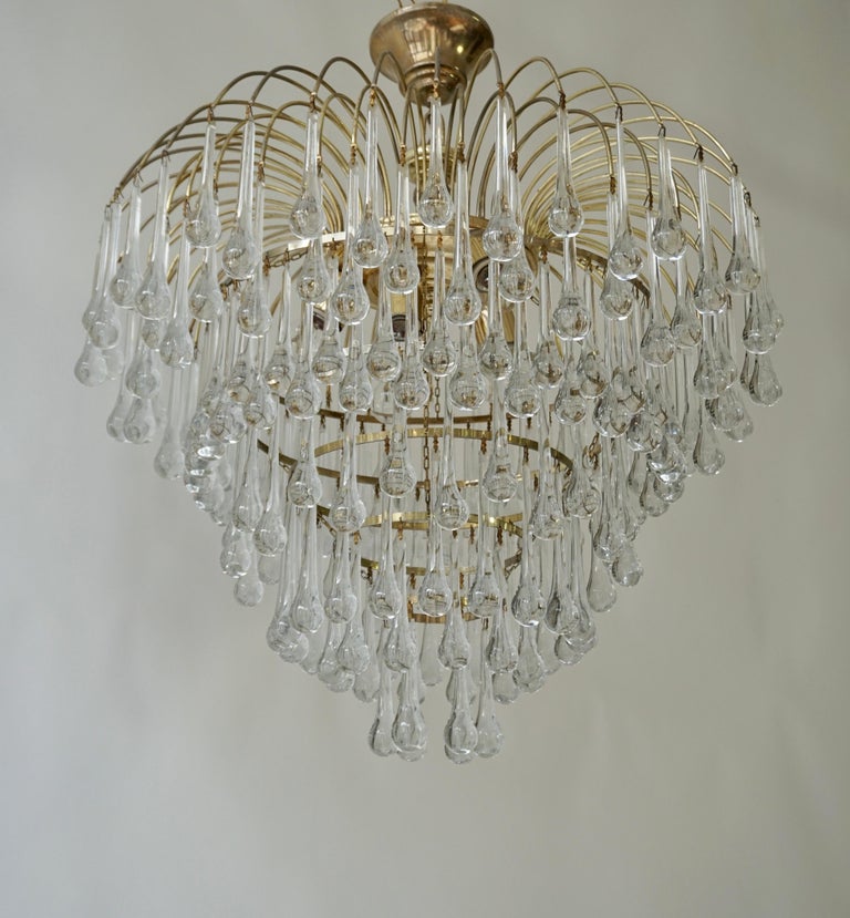 Beautiful and elegant large chandelier with teardrop crystals on a tiered brass base.   

Measures: diameter 27.5