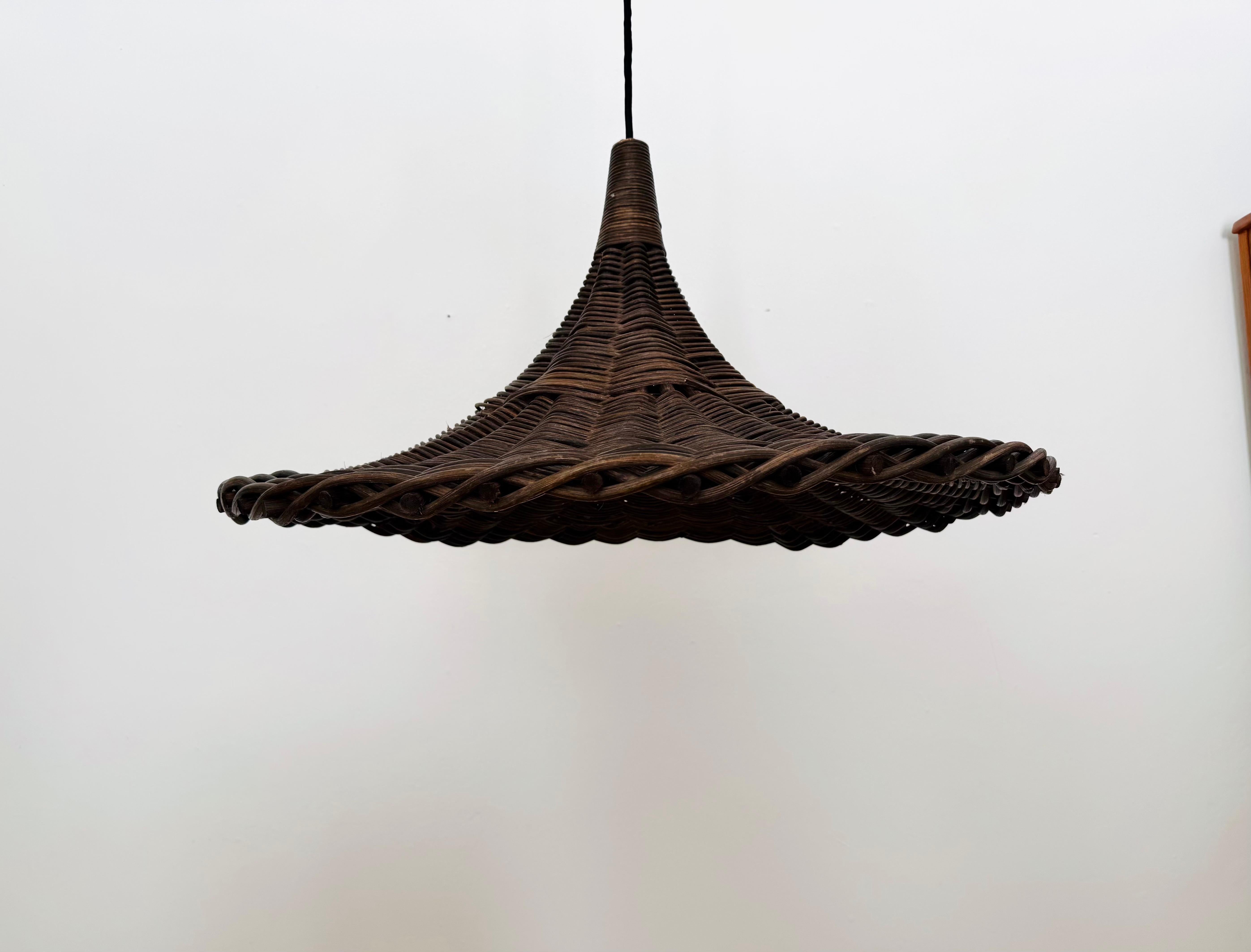 Lampada in rattan Tulip eccezionalmente grande e bella degli anni '70.
Un design straordinario e insolito con un'atmosfera meravigliosamente accogliente.
Realizzato a mano con un bellissimo motivo a treccia sul bordo.
Crea uno spettacolare gioco di