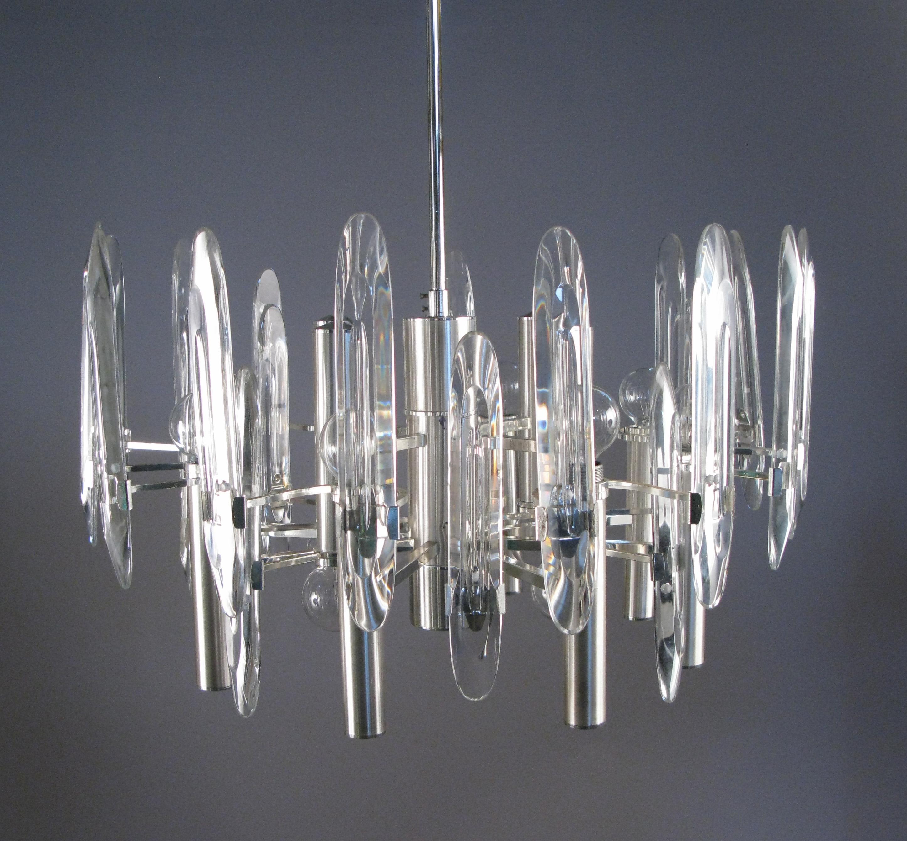 A beautiful and stunning vintage 1960s Italian chandelier by Gaetano Sciolari, with a chrome and brushed aluminum frame, and tall glass panels. The fixture has twelve sockets, allowing for a wide range of light. This is one of Sciolari's most