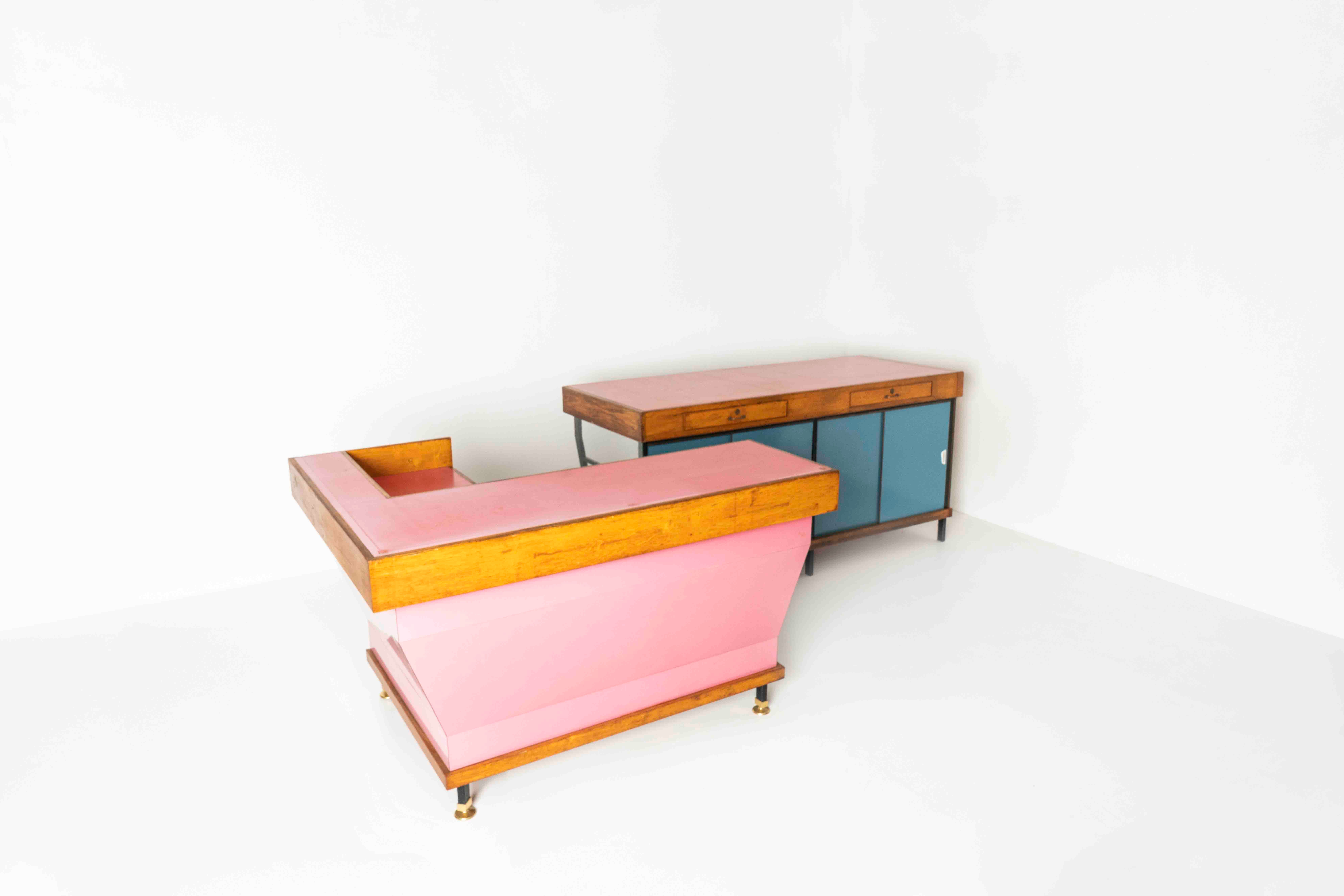 Impressive Italian vintage shop counter set consisting of two pieces from ca the 1960s. This set in 'candy colors' features a corner counter in pink with metal and brass feet. The other element has blue sliding doors, which is the counter's back.