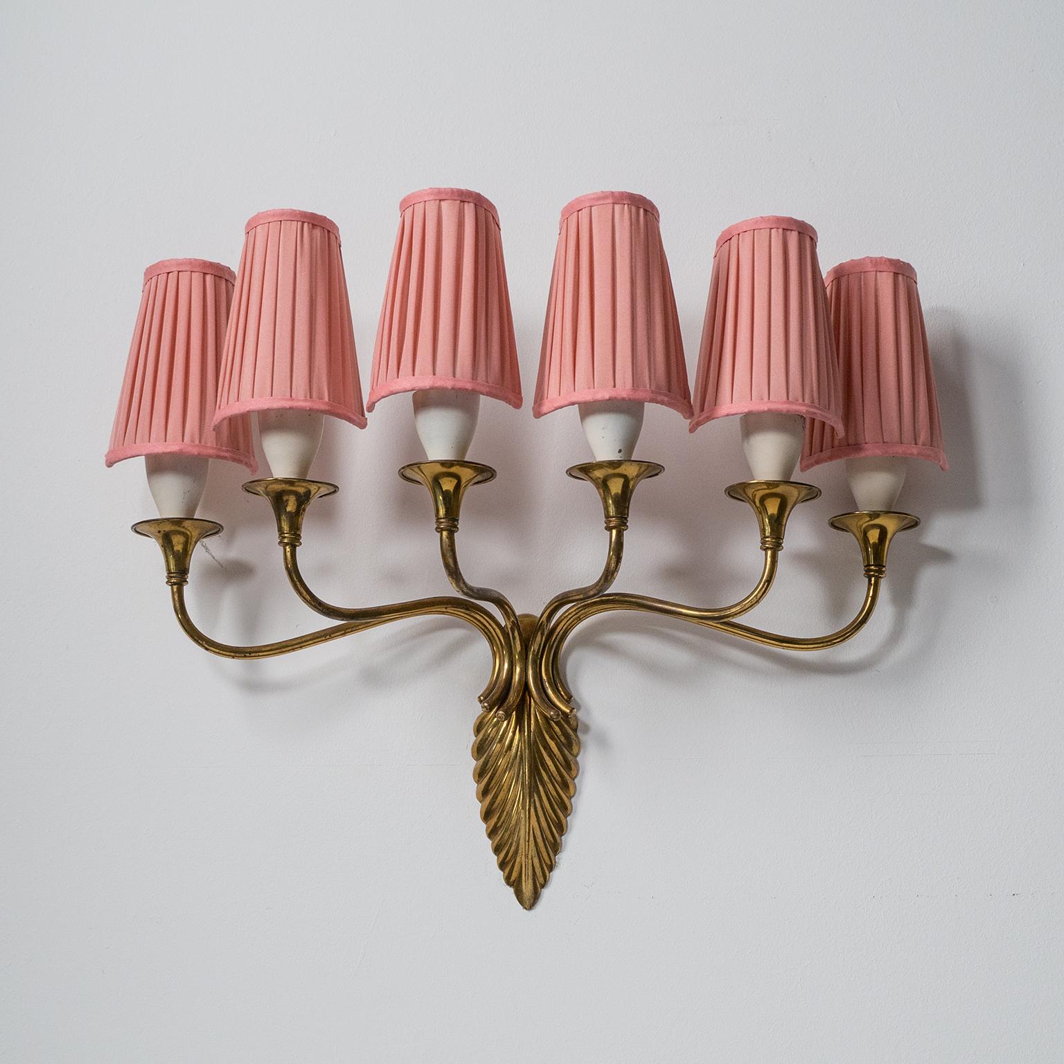 Rare six-arm Italian brass wall light from the 1940s. The leaf-shaped centerpiece is cast brass with six curved arms, each with an off-white lacquered socket cover. Good original condition with patina on the brass and some wear to the original
