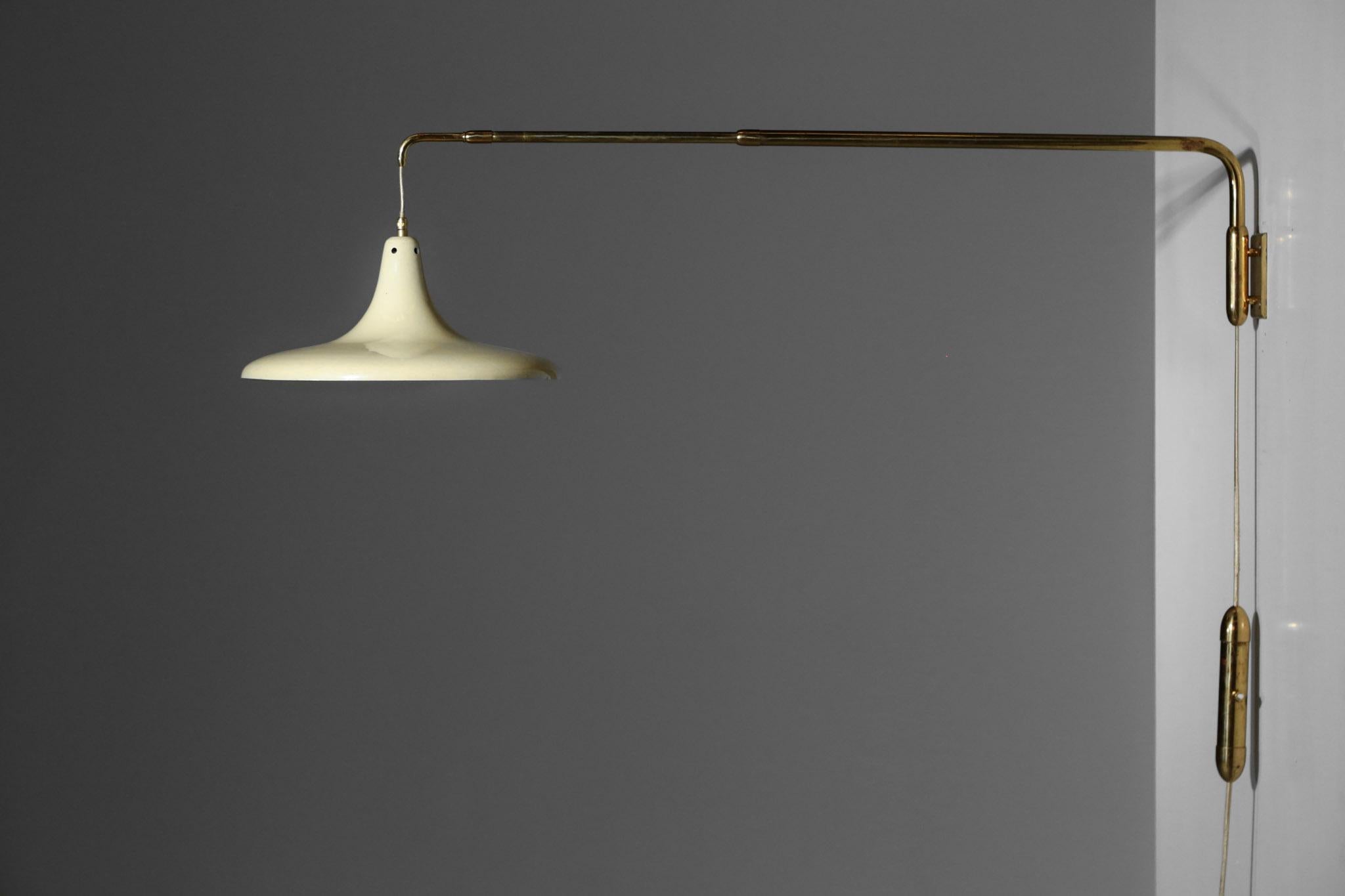Large wall light from Italy, adjustable rod with counter weight system.  Made of brass with beige metal lampshade
Measures: L. max 126 cm (144 with lampshade) / L. min 71 cm (89 cm) / Diam. lampshade 36 cm /  H. 20 cm.