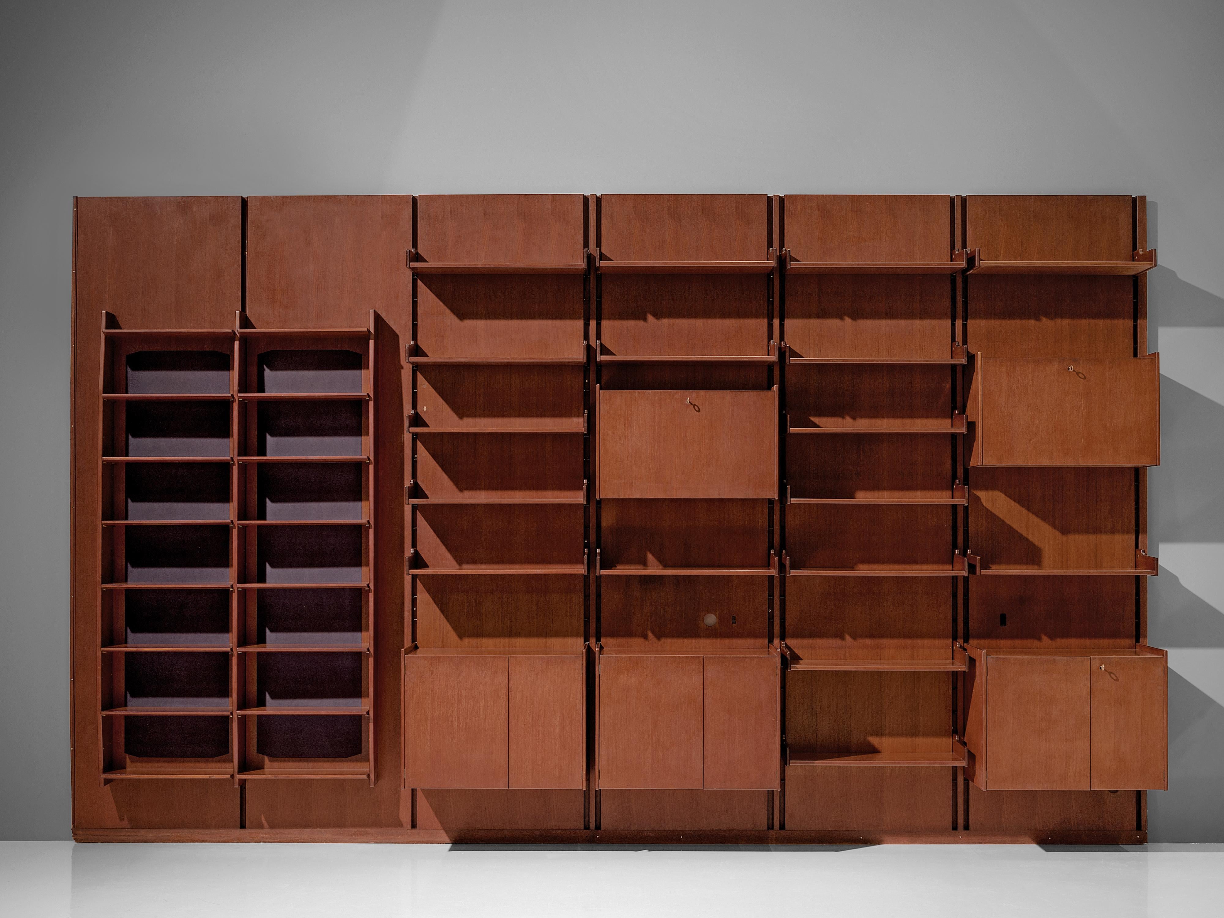 Italian wall unit, teak, brass, metal, Italy, 1950s.

This large wall unit offers a variety of use. The unit consists of six panels with various storage facilities. Multiple shelves, five cabinets with different interior structure and two columns of
