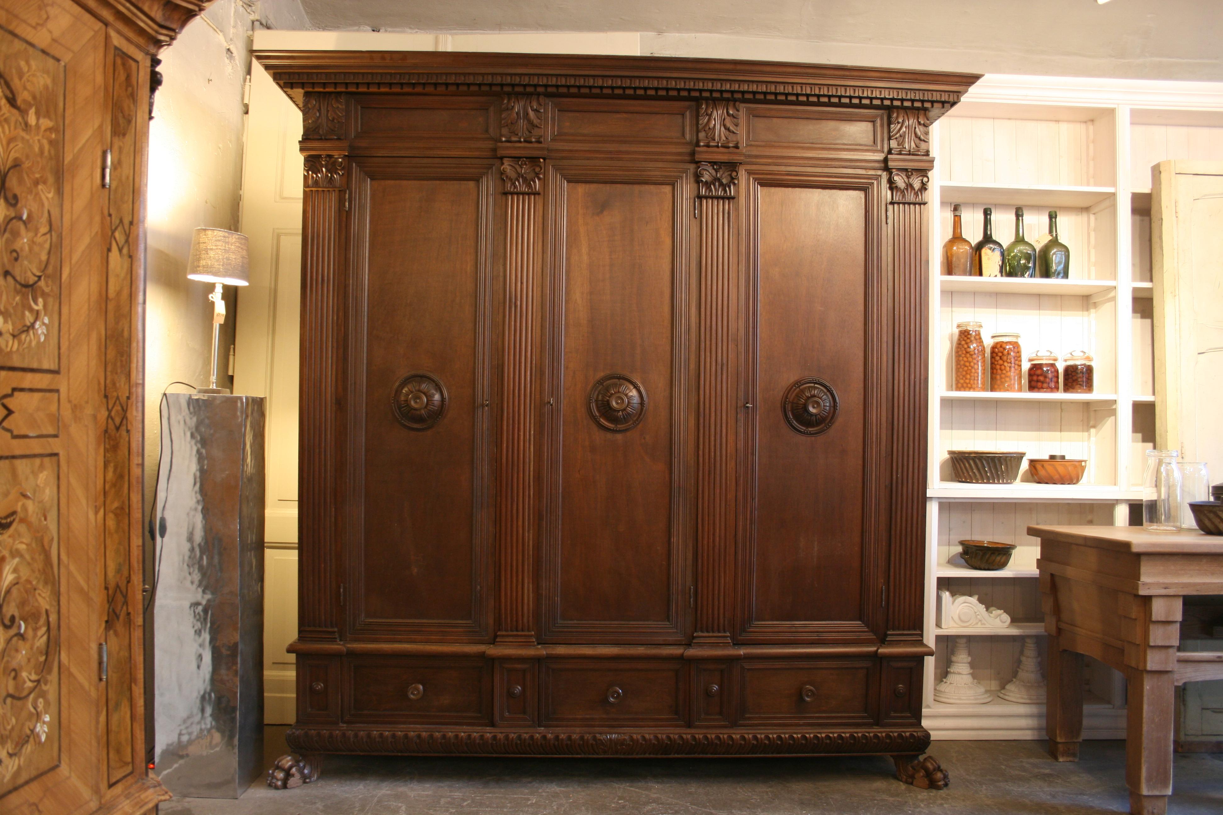 Large antique cabinet from Tuscany in Italy, circa 1900. Exterior completely made of walnut. 3 doors, of which the middle door has a mirror on the inside. Below a small and a large drawer (see pictures). Standing on 4 feet, of which 2 full-plastic