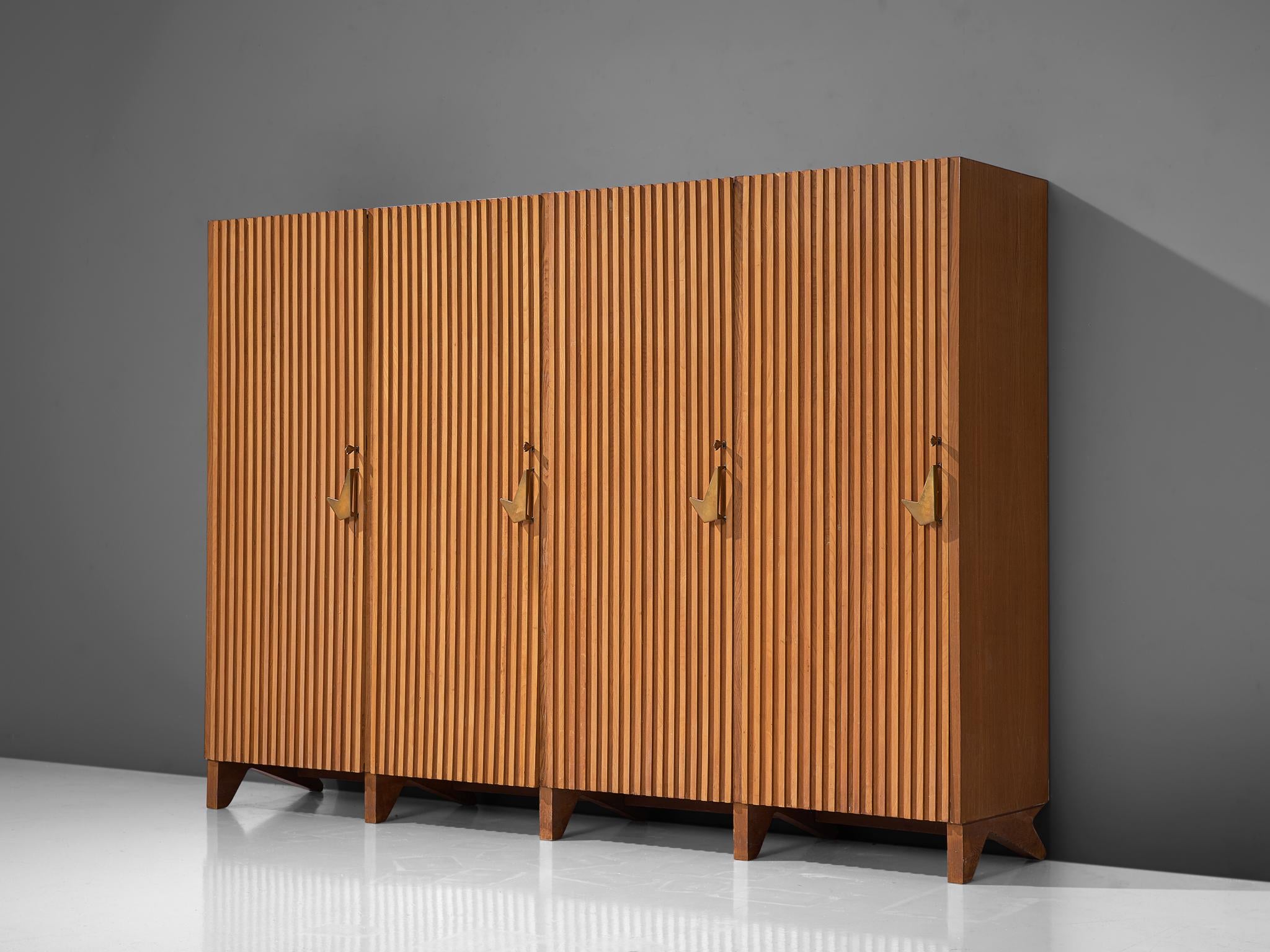 Nestorio Sacchi, cabinet, ashwood and brass, Italy, 1950s.

This grand cabinet is executed in ashwood with brass details and handles. The doors of the armoire are finished with vertical wooden slates that run from the bottom all the way to the