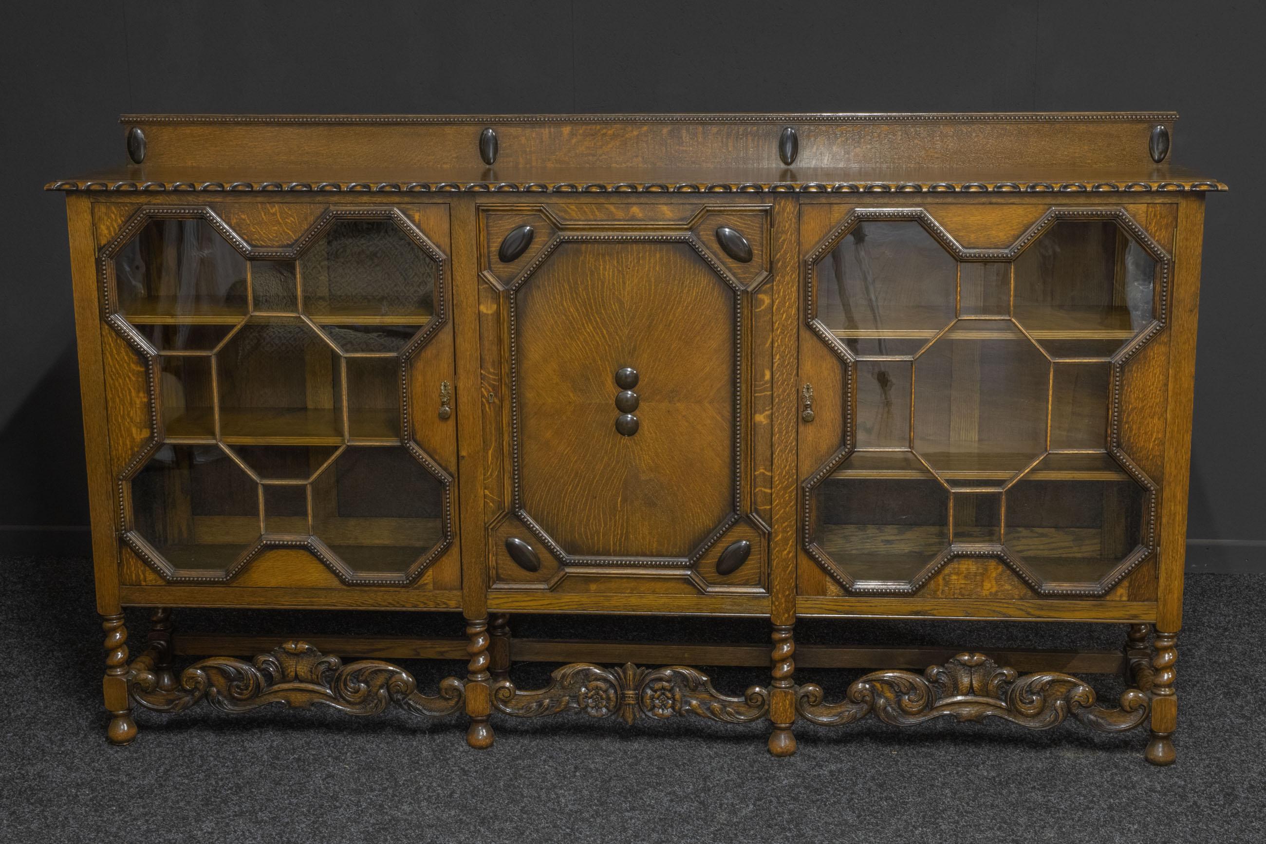 A superb solid oak bookcase designed in the Jacobean style. The octagonal geometric framing to the glazed doors is most unusual, as are the carved stretchers to the base. An unusually long bookcase that will look fantastic in the right setting as