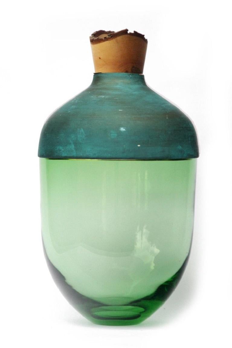 Large jade and copper patina India vessel I, Pia Wüstenberg.
Dimensions: D 30 x H 55.
Materials: glass, wood, copper.
Available in other metals: brass, copper, copper patina.

Handmade in Europe, by individual craftsmen: handblown glass (Czech