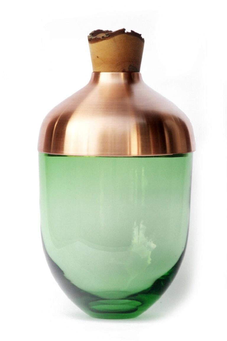 Large Jade India vessel I, Pia Wüstenberg.
Dimensions: D 30 x H 55.
Materials: glass, wood, metal.
Available in other metals: brass, copper, copper patina.

Handmade in Europe, by individual craftsmen: handblown glass (Czech Republic), hand