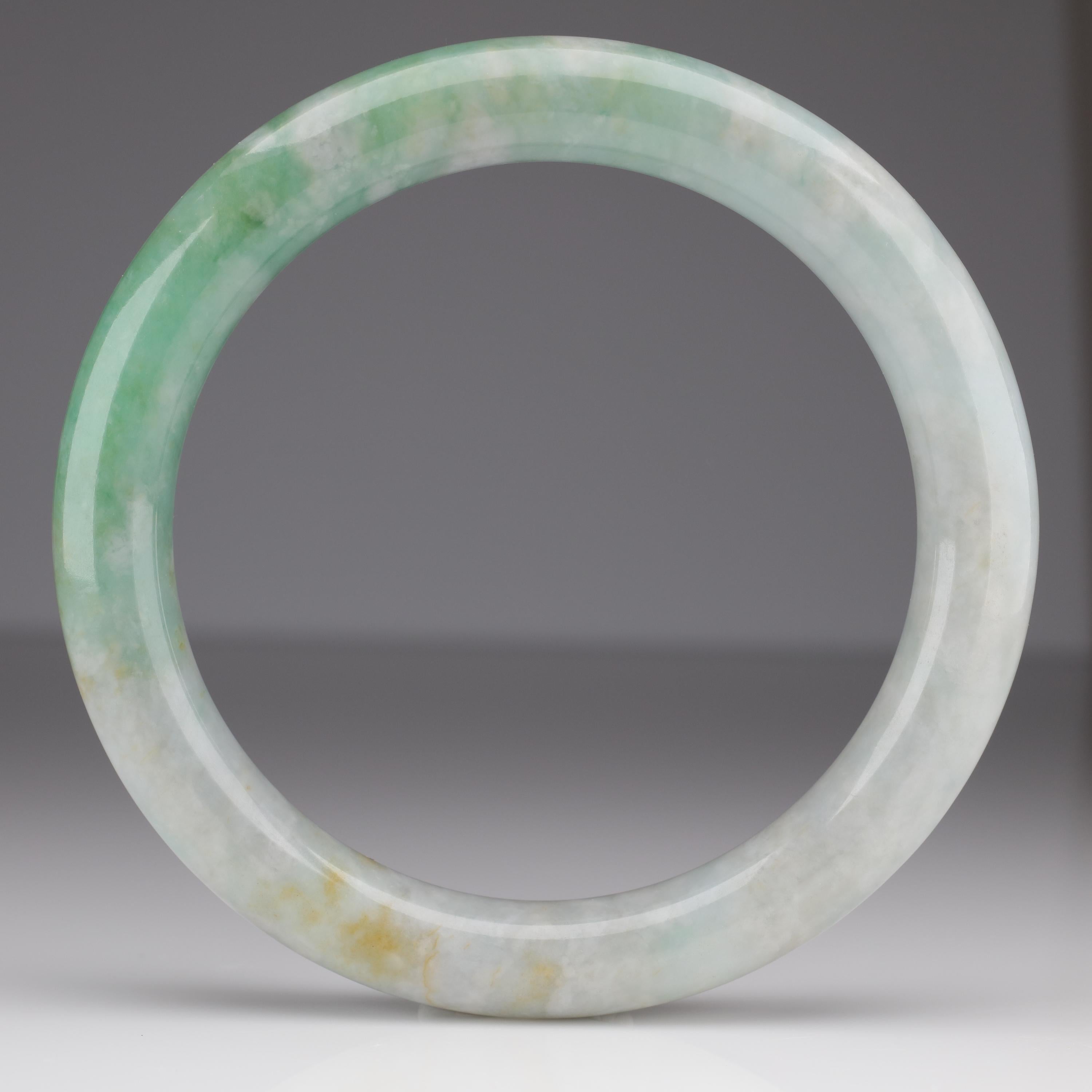 This is a large and heavy jade bangle carved for a man. The opening is 70mm, which will allow men with even large hands (like me) to wear it. The ideal fit for a jade bangle is one where the bangle could not possibly slide off your wrist when your