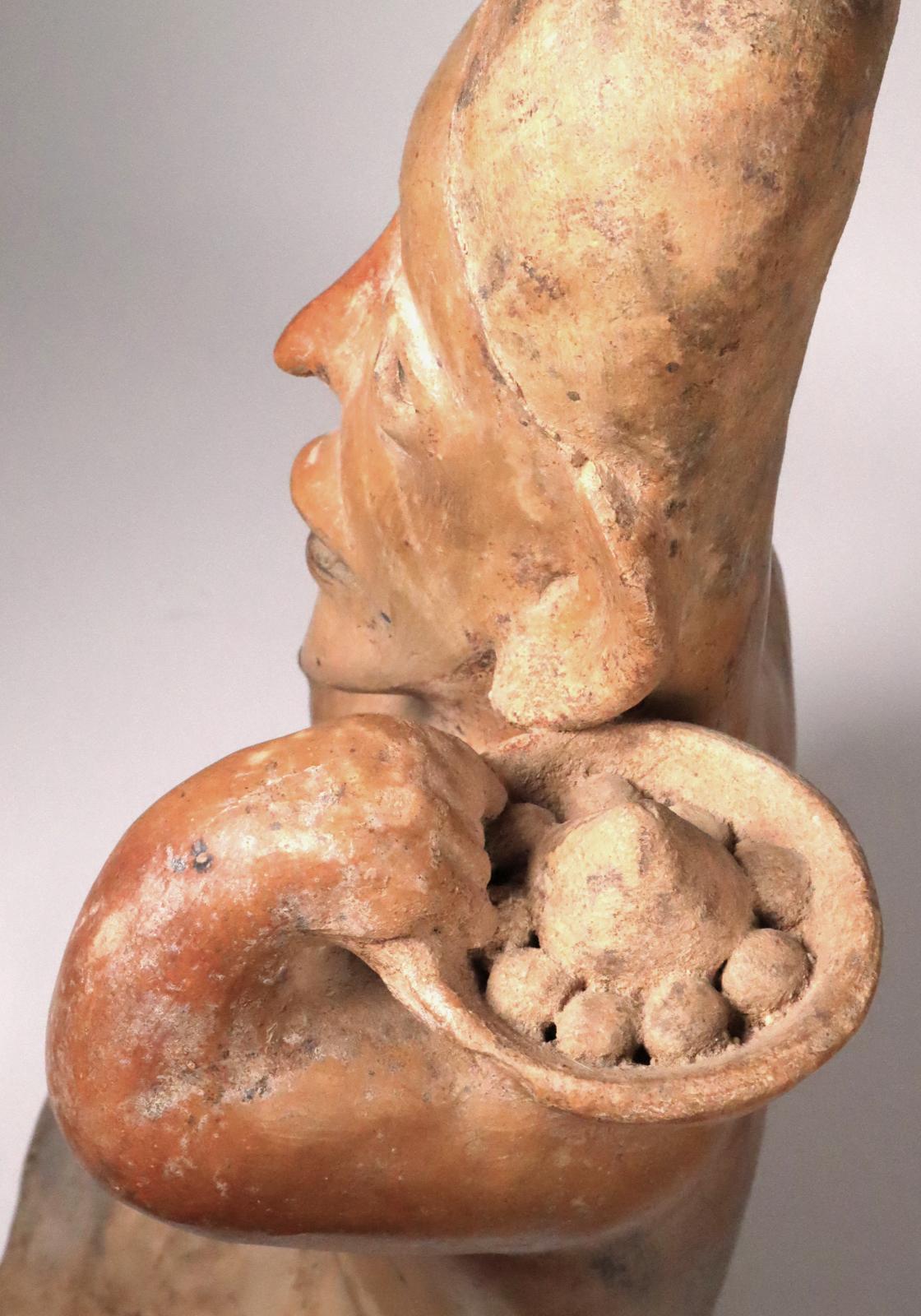 Large Jalisco kneeling female holding bowl of food on her left shoulder and rubbing her tummy. Fantastic, strong, Picasso-like asymmetric face. The mouth open as if speaking or singing; 