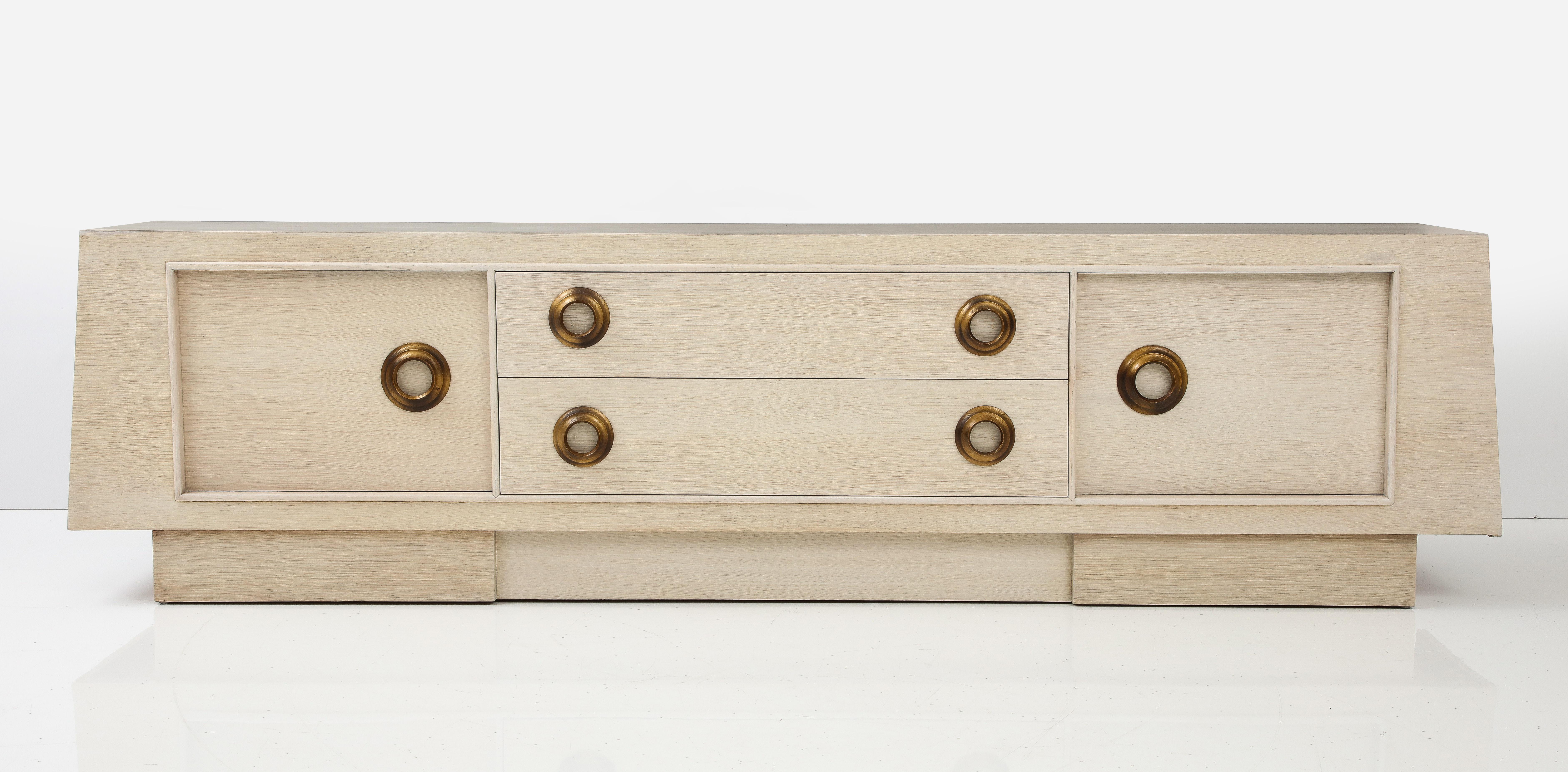 Superbe grand meuble en chêne blanchi de James Mont.
L'armoire a été nouvellement refinie en chêne blanchi naturel et est
accentué par des tirettes dorées à l'ancienne.