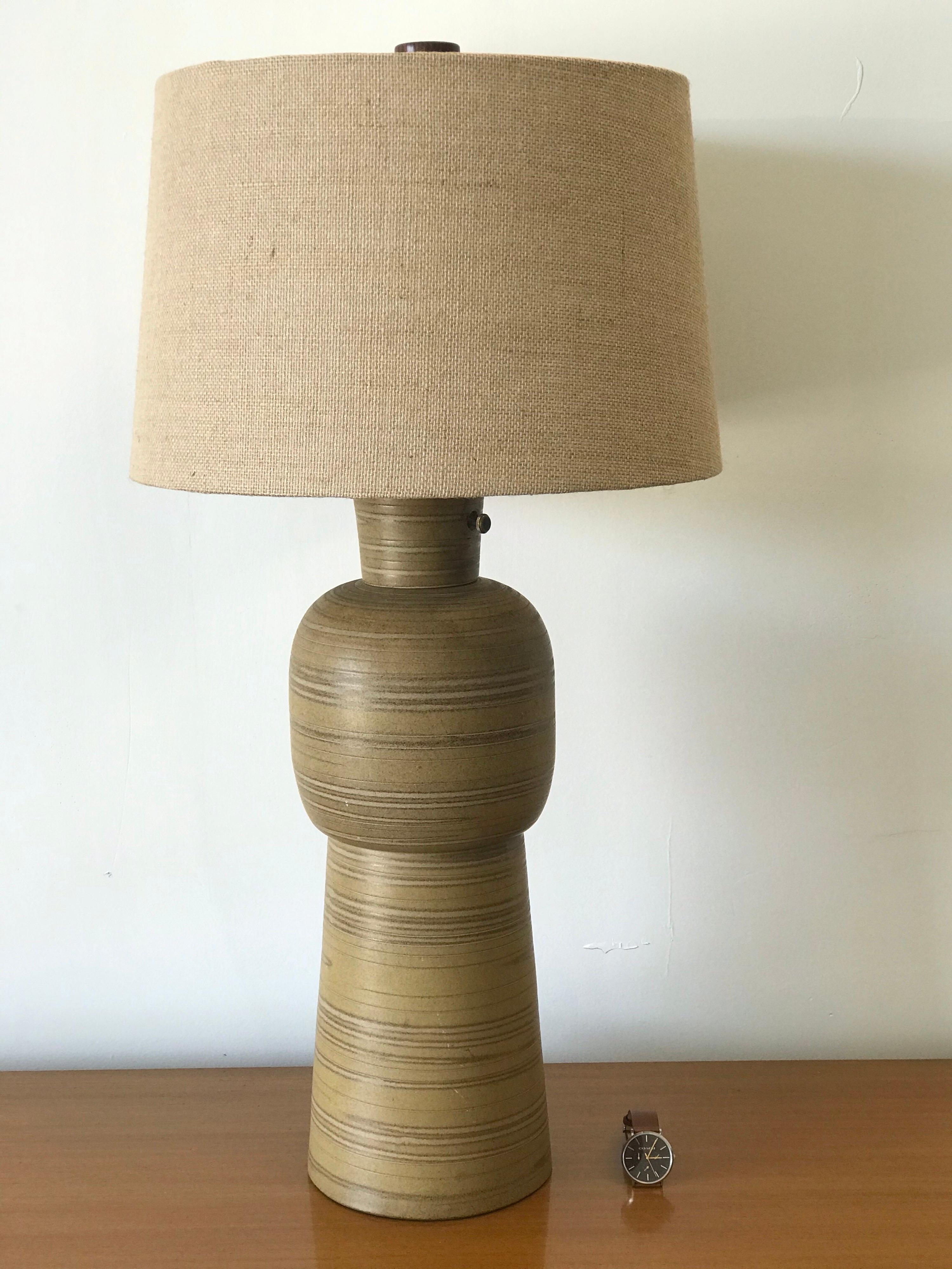 Monumental table lamp by ceramicist duo Jane and Gordon Martz. Features a matte glaze of yellow and gold swirls. Unique design with a hole for the switch. Very good vintage condition. Shade is new and finial has been replaced with a true to original