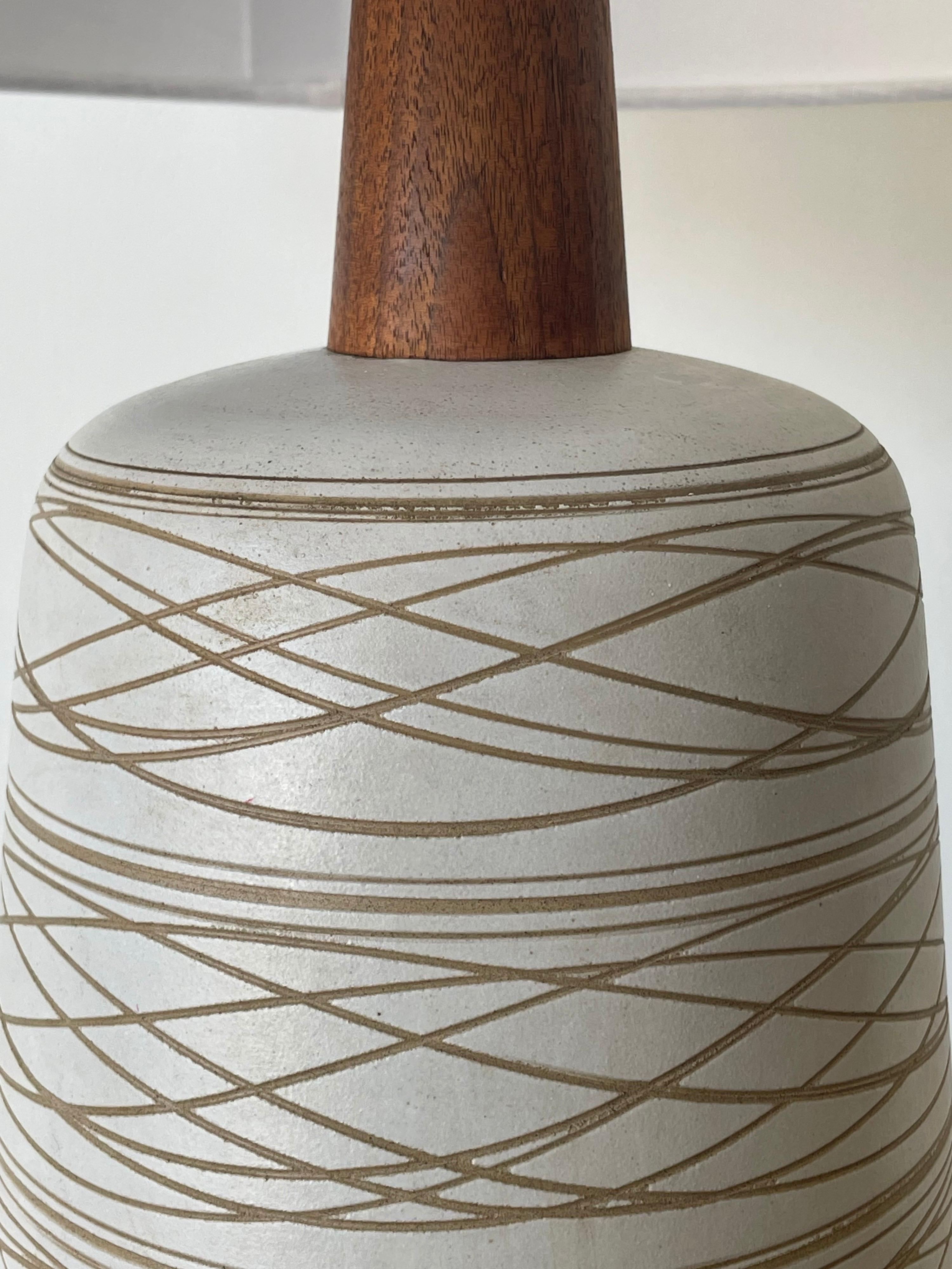 Large Martz lamp by ceramicist duo Jane and Gordon Martz for Marshall Studios. Features a white/ off white glaze with incised tan pattern. Walnut base, neck, and finial.

Overall;
32” talll
17” wide 

Base
7” wide
17.5” tall.