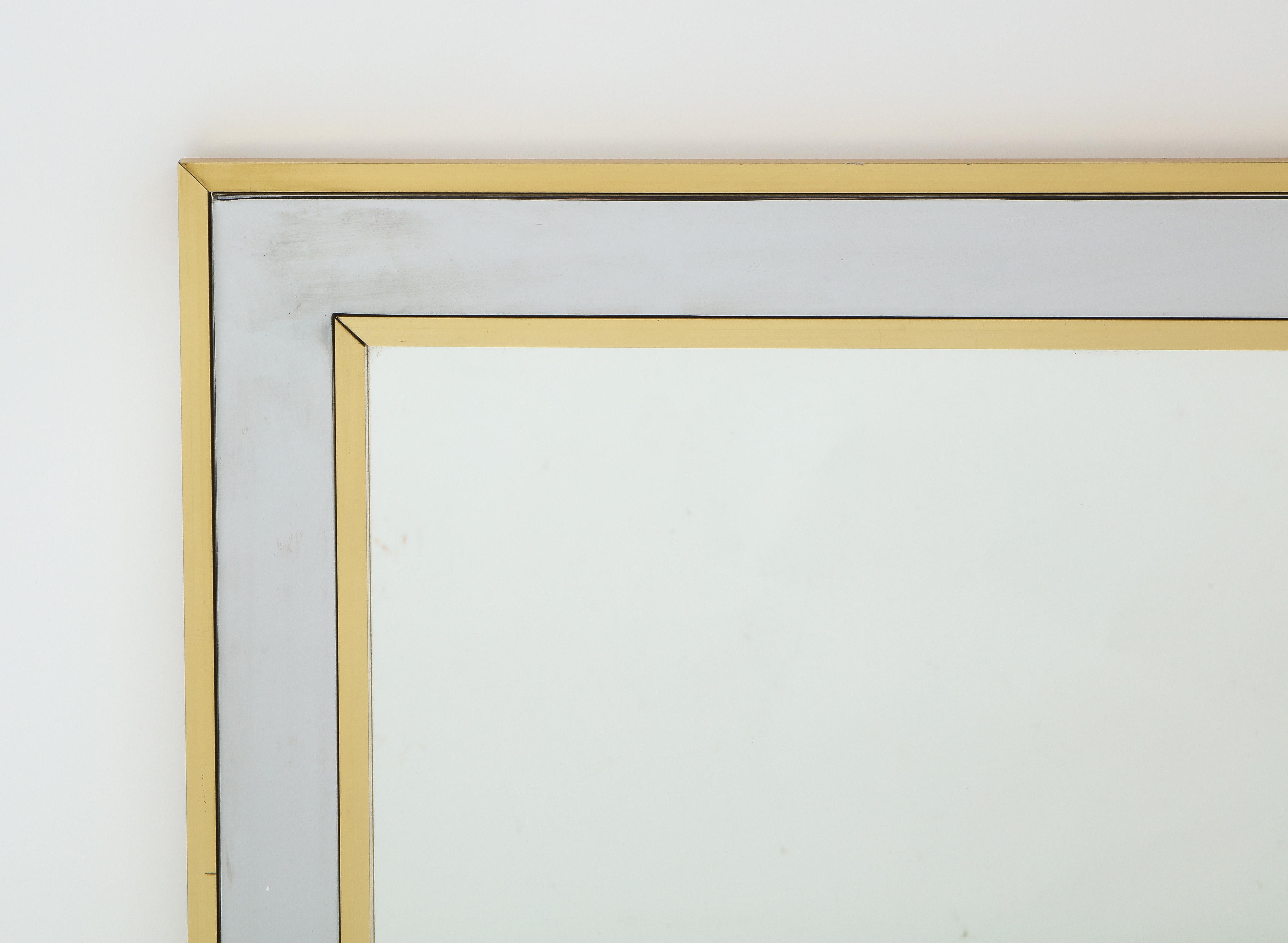 Large Jansen mirror in brass and nickel-plated brass, the narrow mirror like surround in between the brass trims is nickel-plated brass.