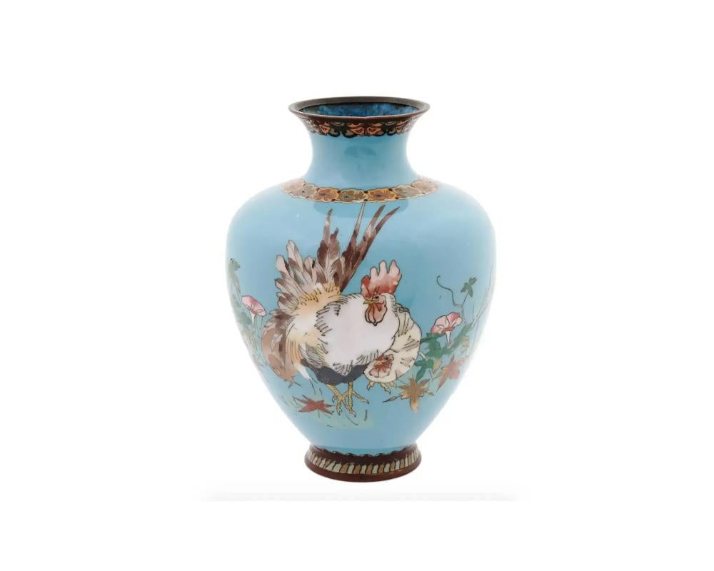 A large Japanese amphora shaped enamel over brass vase. The vase is enameled with polychrome images of a rooster and a hen in flowers and leaves made in the Cloisonne technique on turquoise ground. The neck and the base of the ware are enameled with