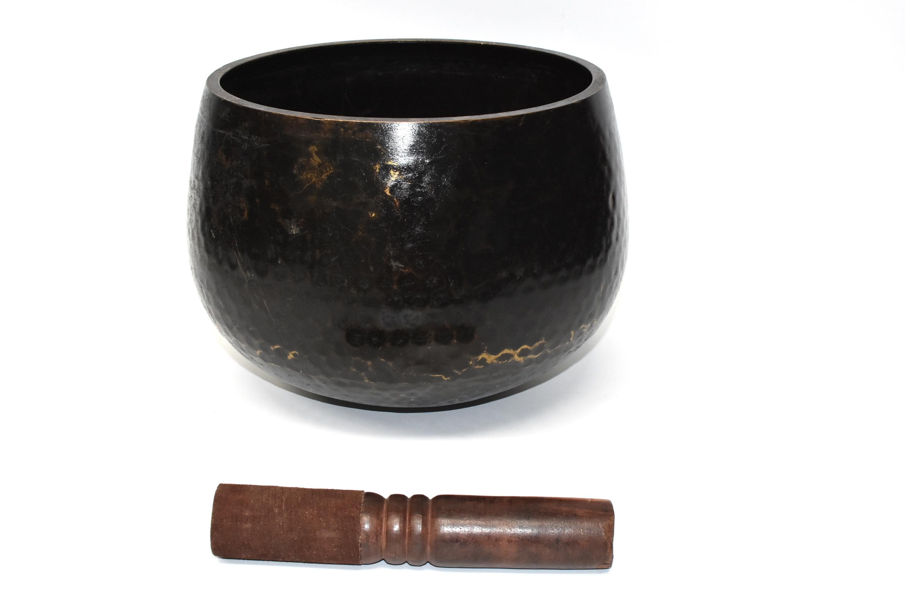 This is a large, substantial antique Japanese singing bowl in black finish. The material is solid bronze. All patina is original. The beautiful beehive patterned dimples are hand hammered. This bowl makes the most beautiful, enlightening, deep sound
