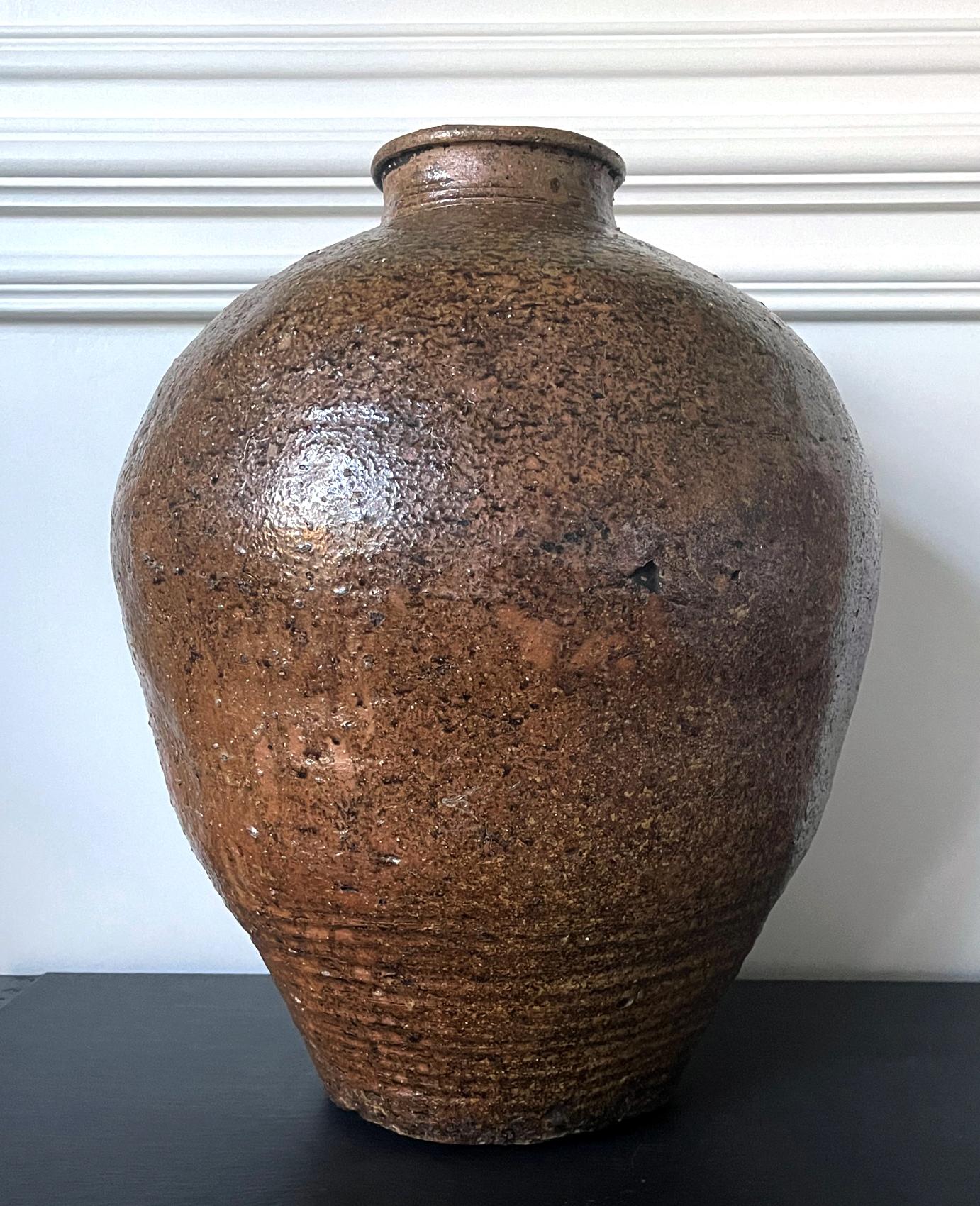 A massive antique stoneware storage jar (known as tsubo in Japanese) circa 16-17th century (Muromachi to early Edo period). The heavily potted jar is of a typical 
