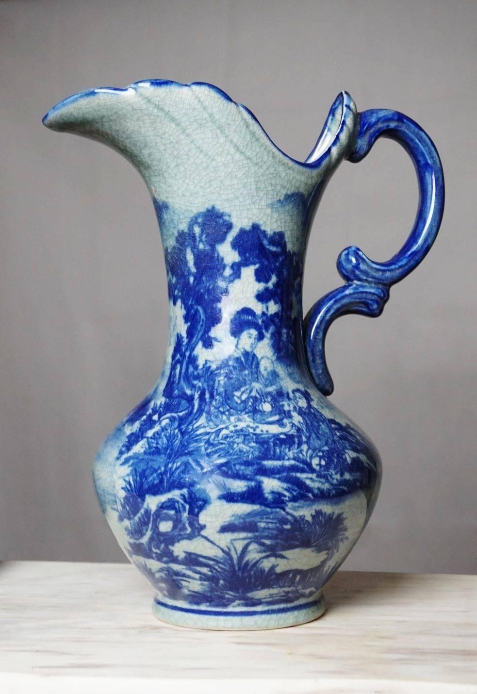Large Japonism blue and white crackle glazed hand painted ceramic handle vase or jug with under plate.

Measures:
Jug
Height 13.50 in (35 cm)
Width with handle 11 in (28 cm) 

Plate: Diameter 11.75 in (30 cm).

 