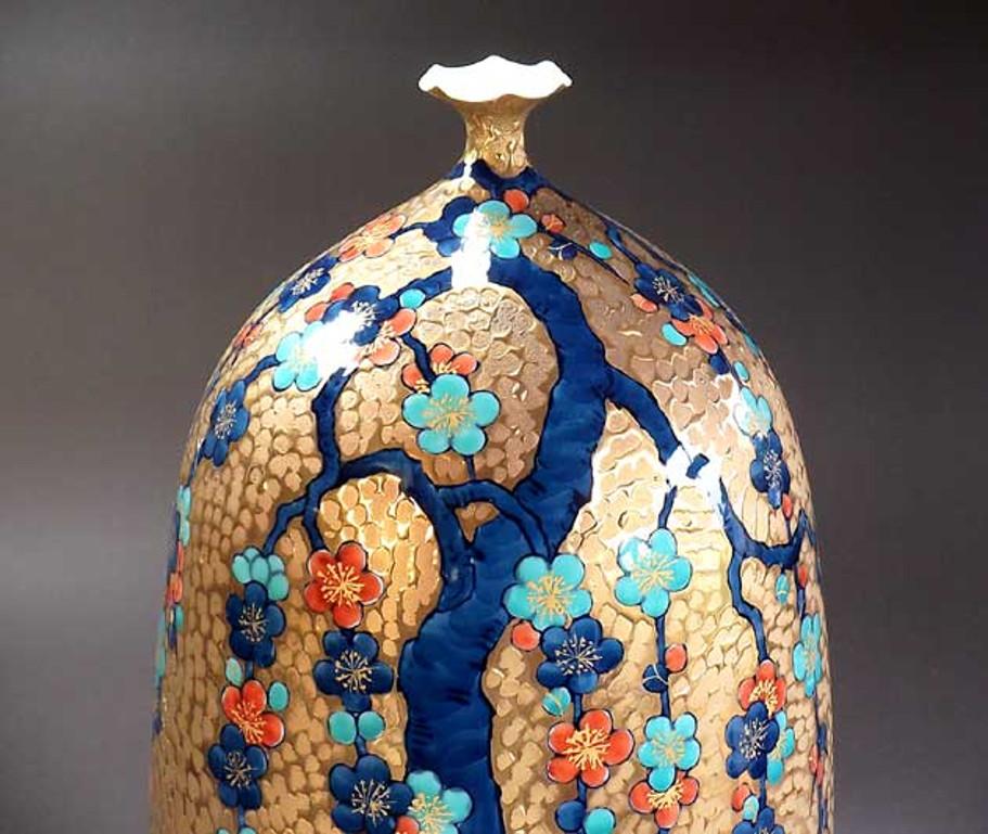 Exceptional large gilded, dimpled signed decorative porcelain vase, an exquisite piece crafted, gilded and hand-painted in vivid blue, turquoise and red, a signed masterpiece by highly acclaimed master porcelain artist in Imari-Arita style and the