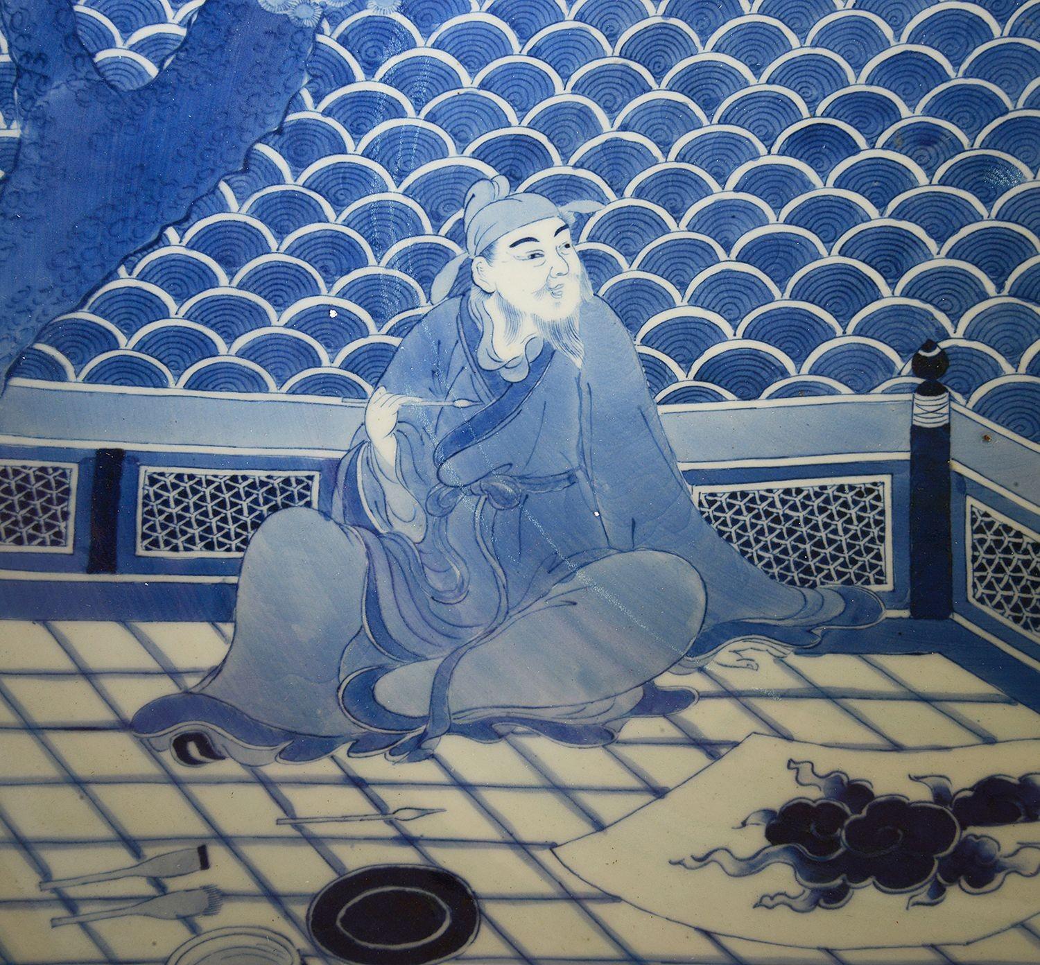 Cet exquis chargeur japonais en porcelaine bleue et blanche de la période Meiji, mesurant 73 cm de diamètre, témoigne de l'art de la céramique japonaise traditionnelle. Le motif complexe présente une scène sereine avec un personnage contemplatif